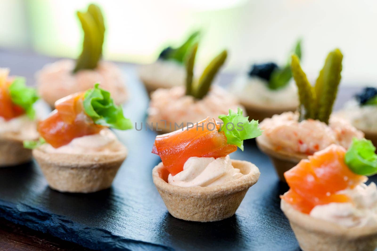 Macro close up of Mini puff pastry tartlets with smoked salmon,creamy crab and savory filling..