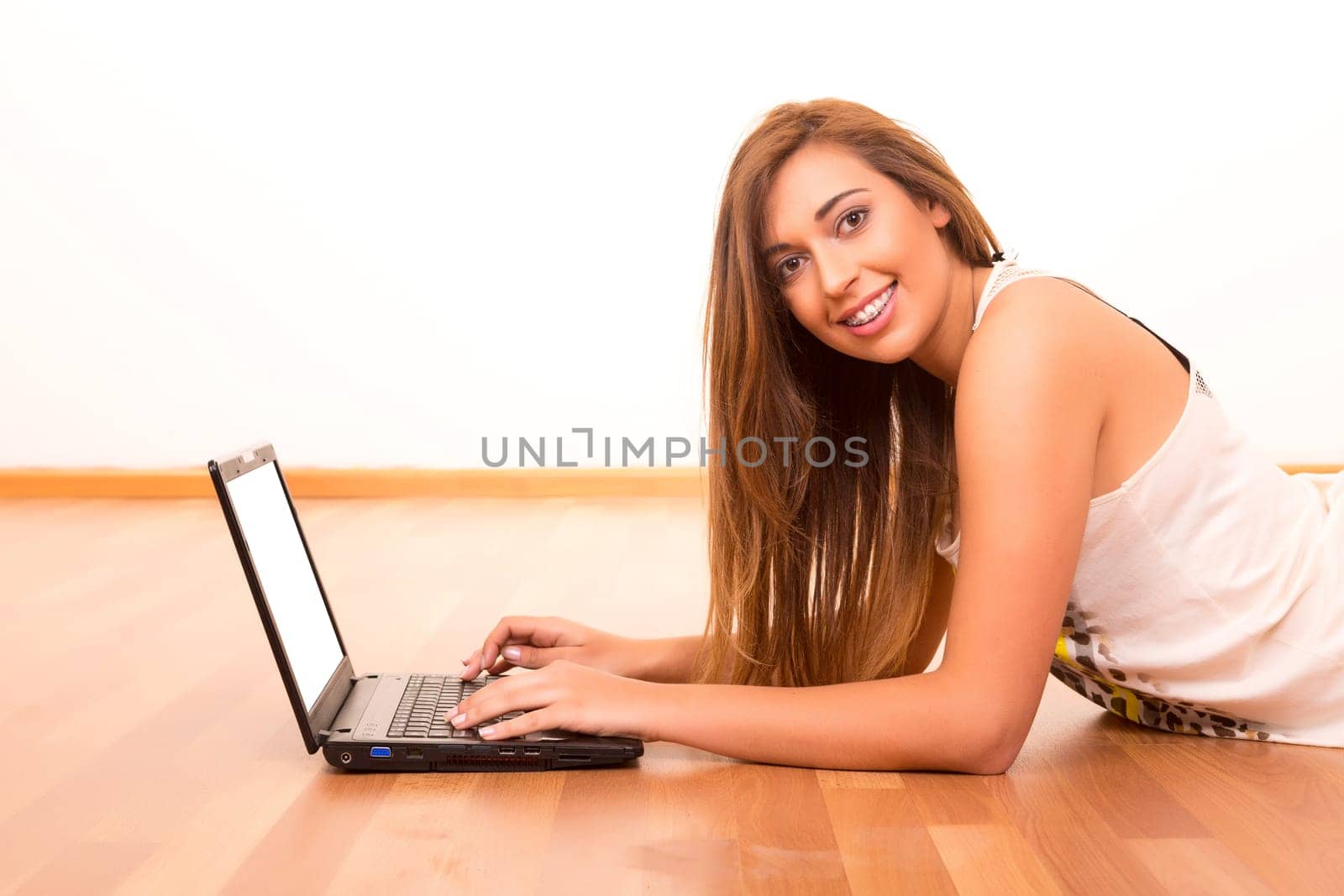 Beautiful teenager relaxing at her living room with the company of a last generation computer
