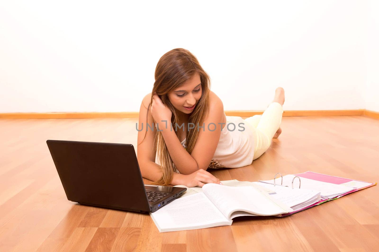 Beautiful teenager who wears braces, studying in her living room