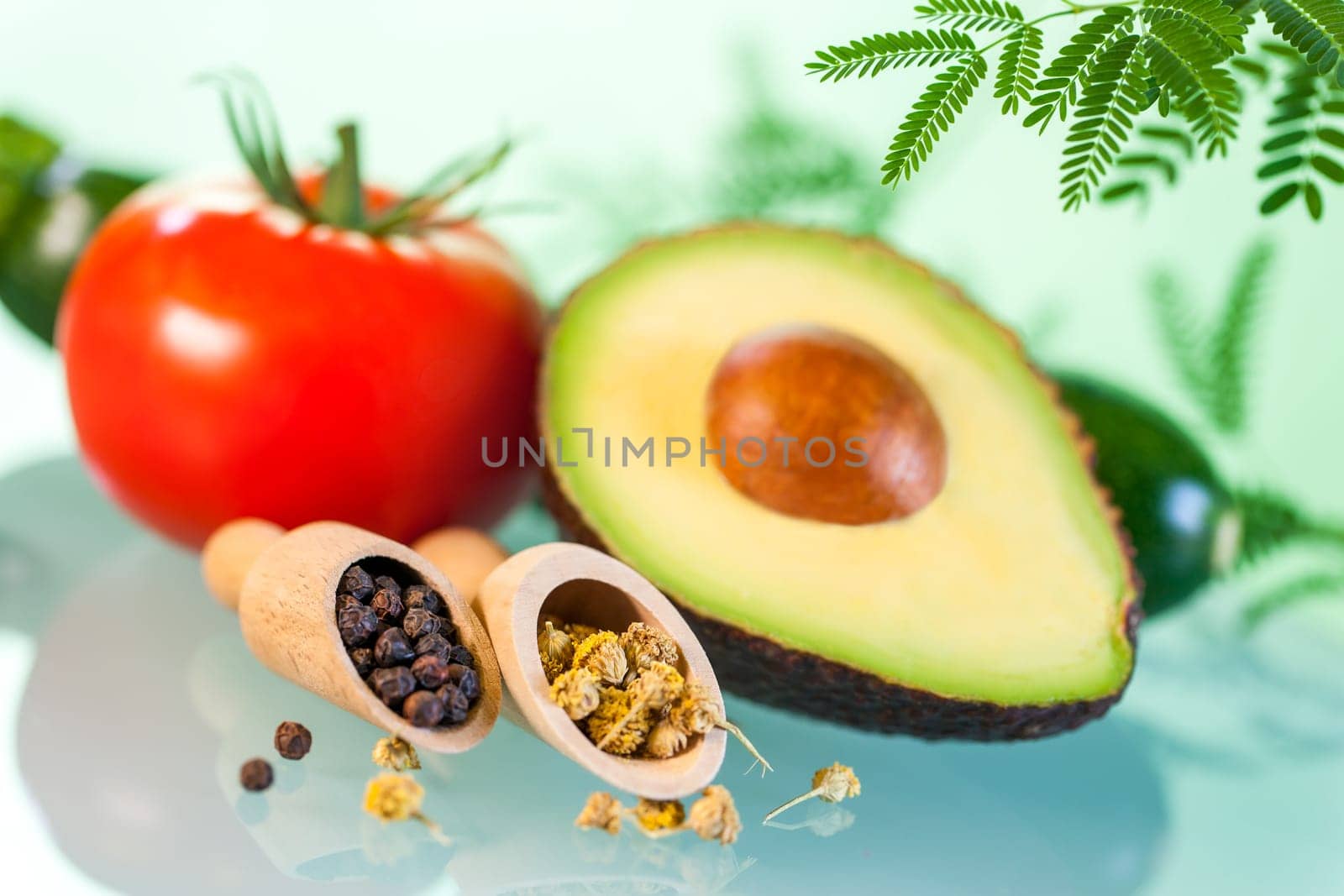 Macro close up Still life of Naturopathic products.Avocado with herbs and seeds against green background.