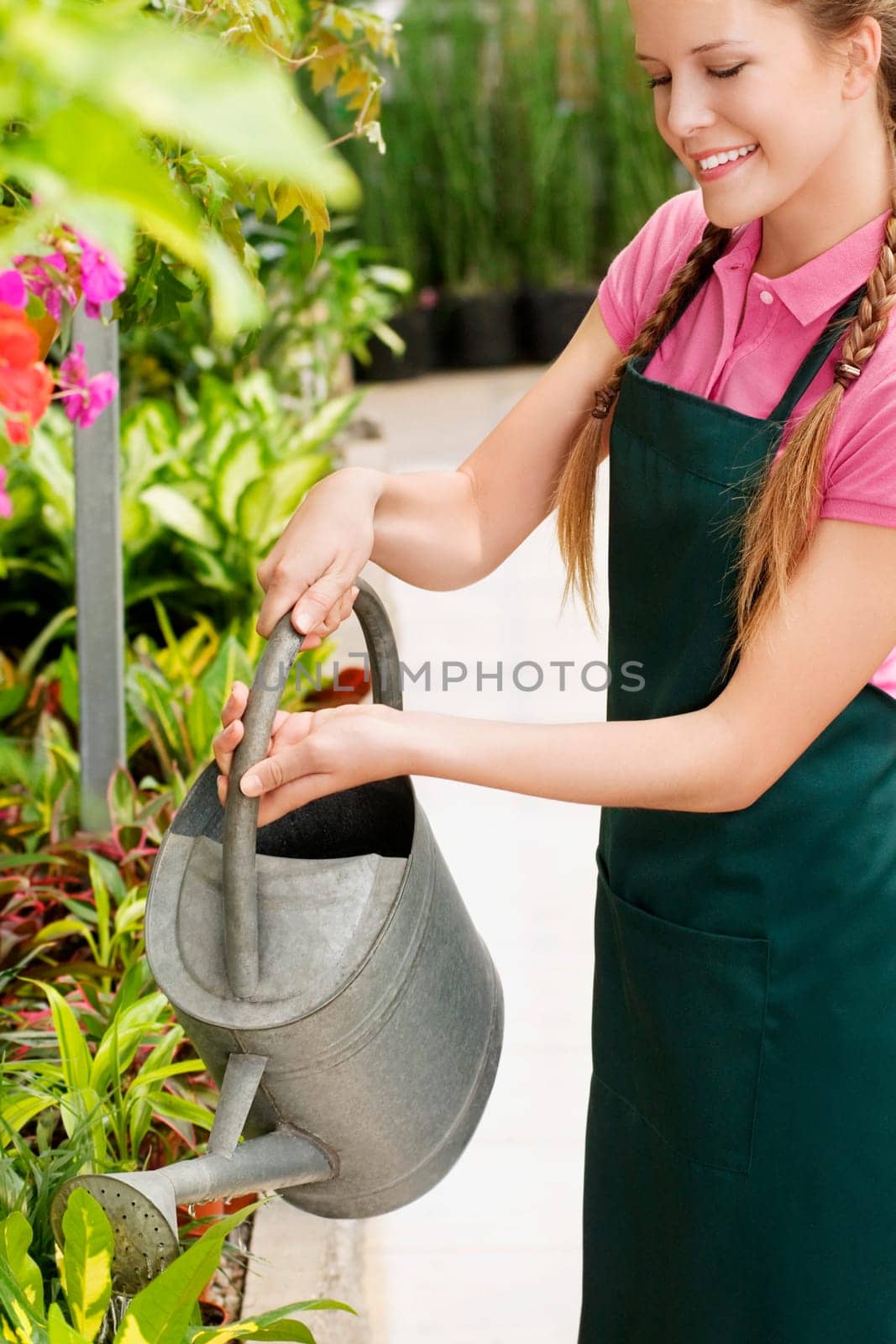 Woman watering plants in a greenhouse