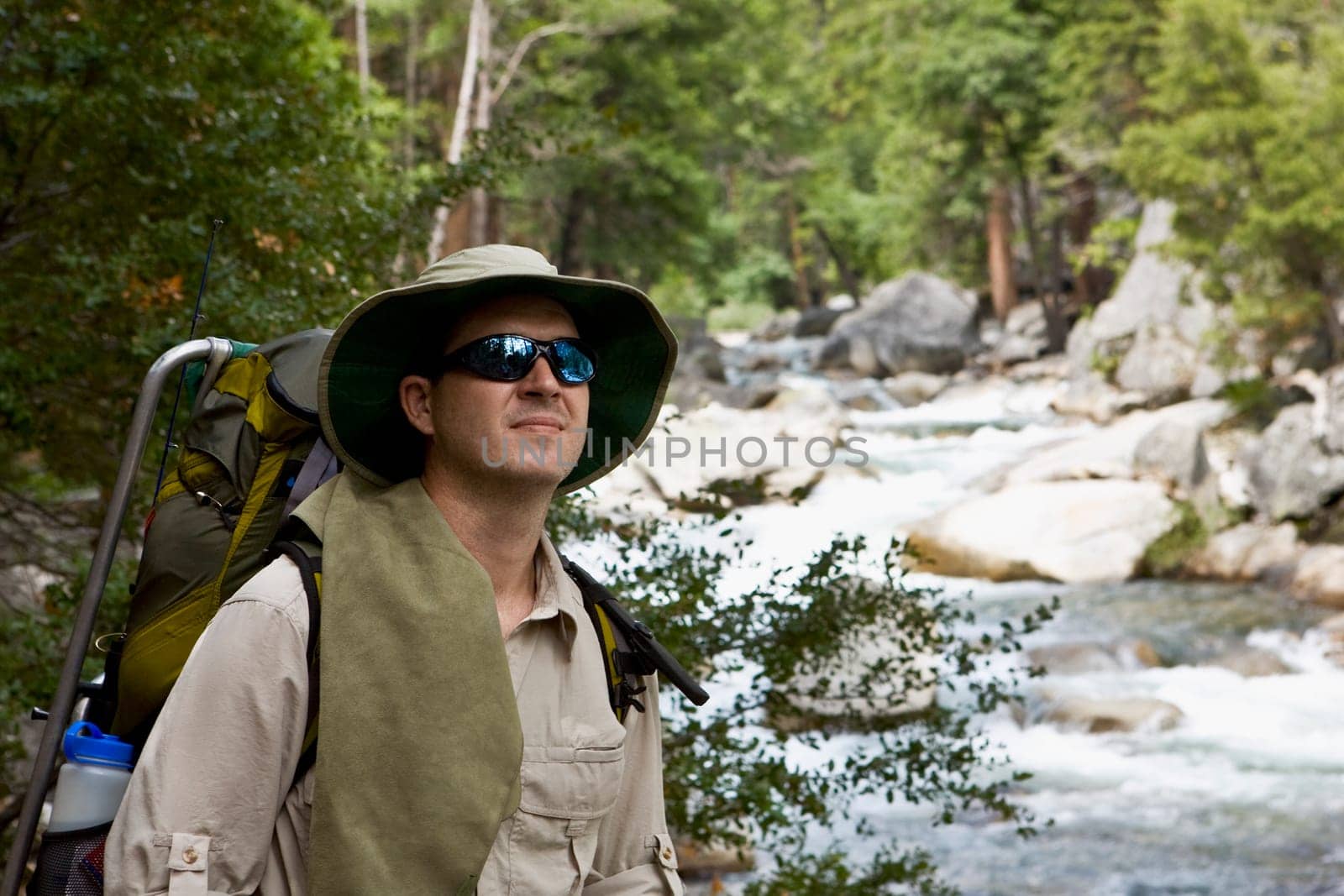 Close_up of a hiker standing at the riverside