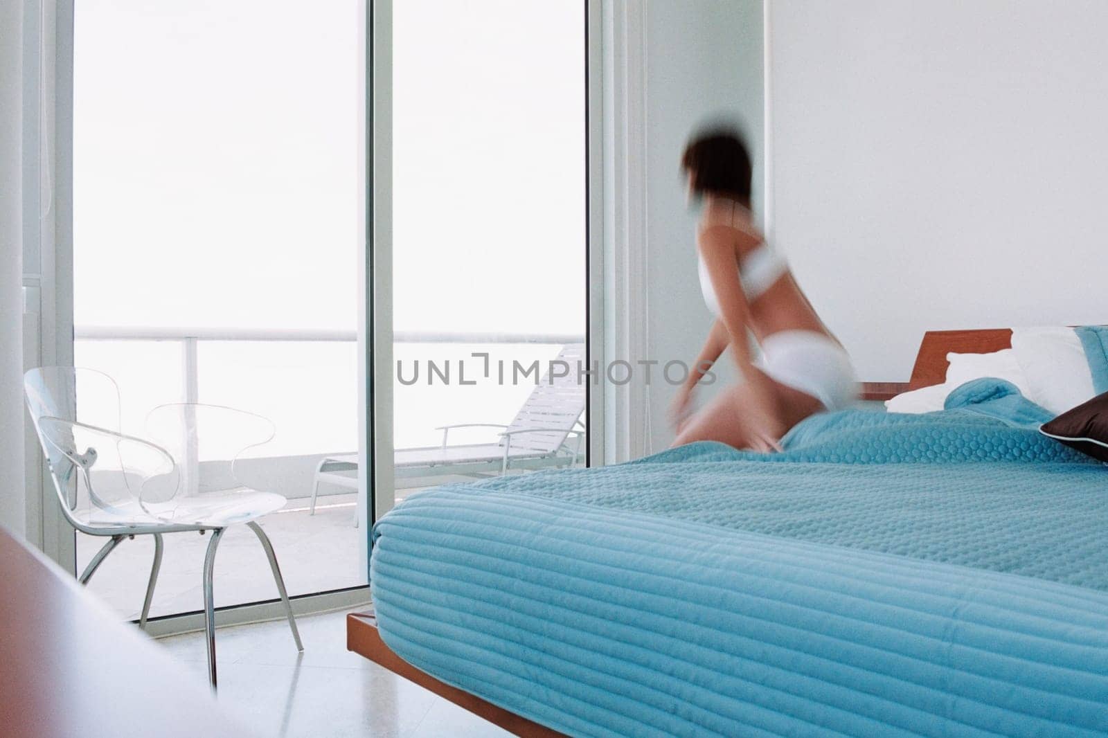 Rear view of a young woman waking up from the bed