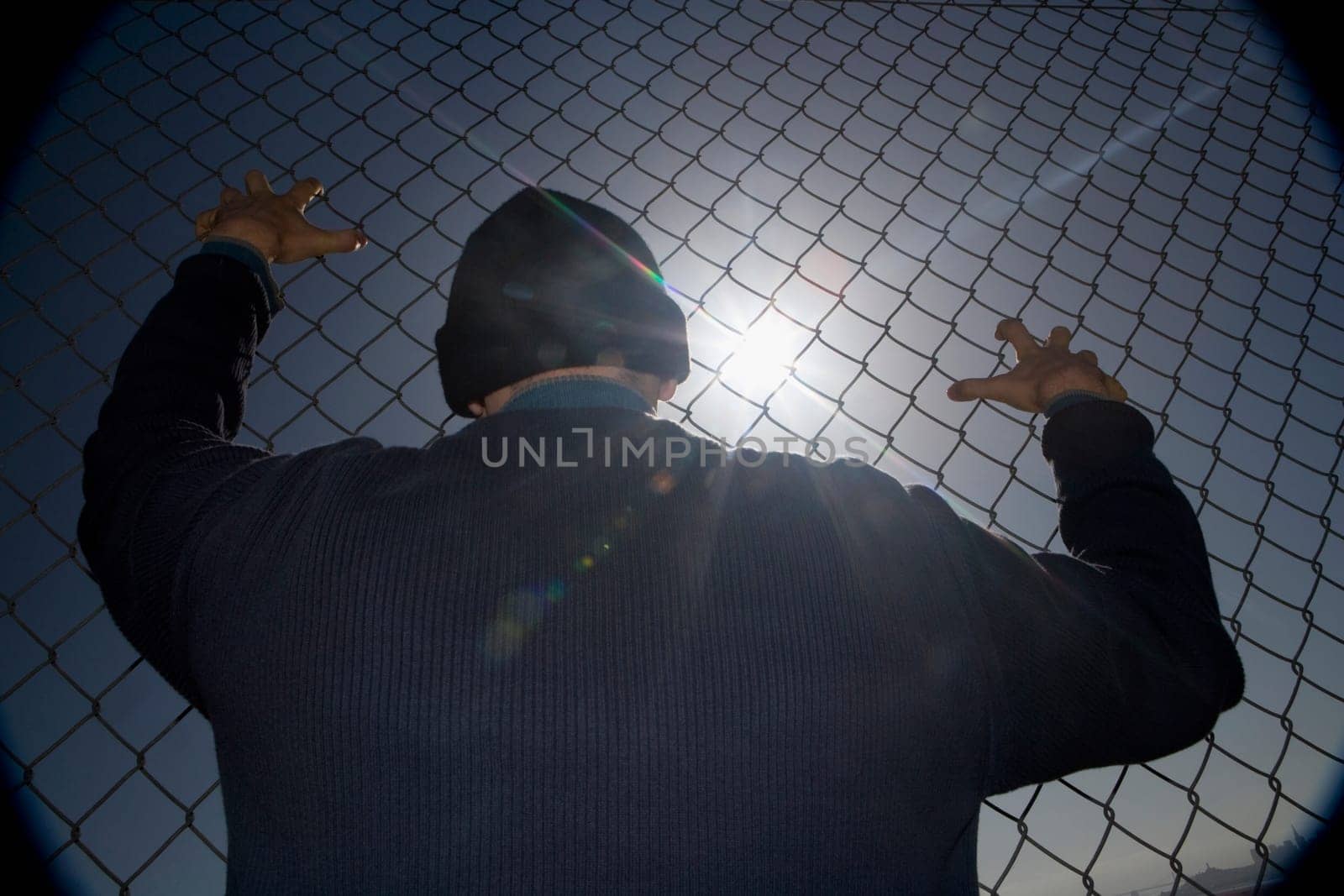 Prisoner clinging to a chainlink fence