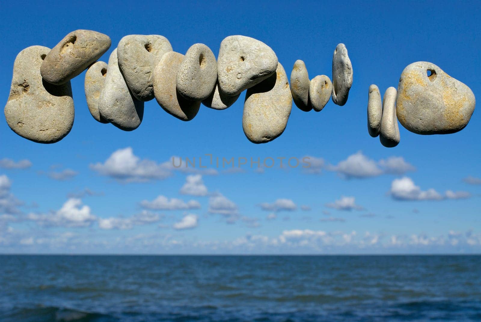 Pebbles in air with sea in the background