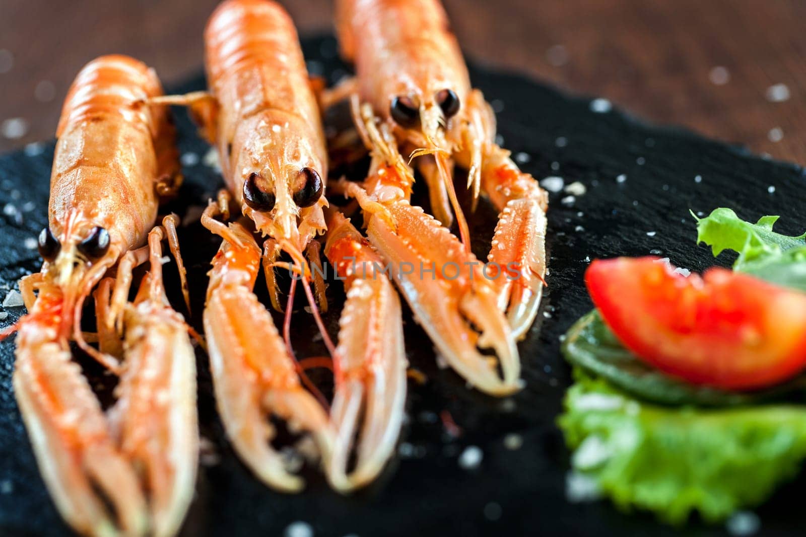 Macro close up of Appetizing spiny lobster platter with green salad in foreground.