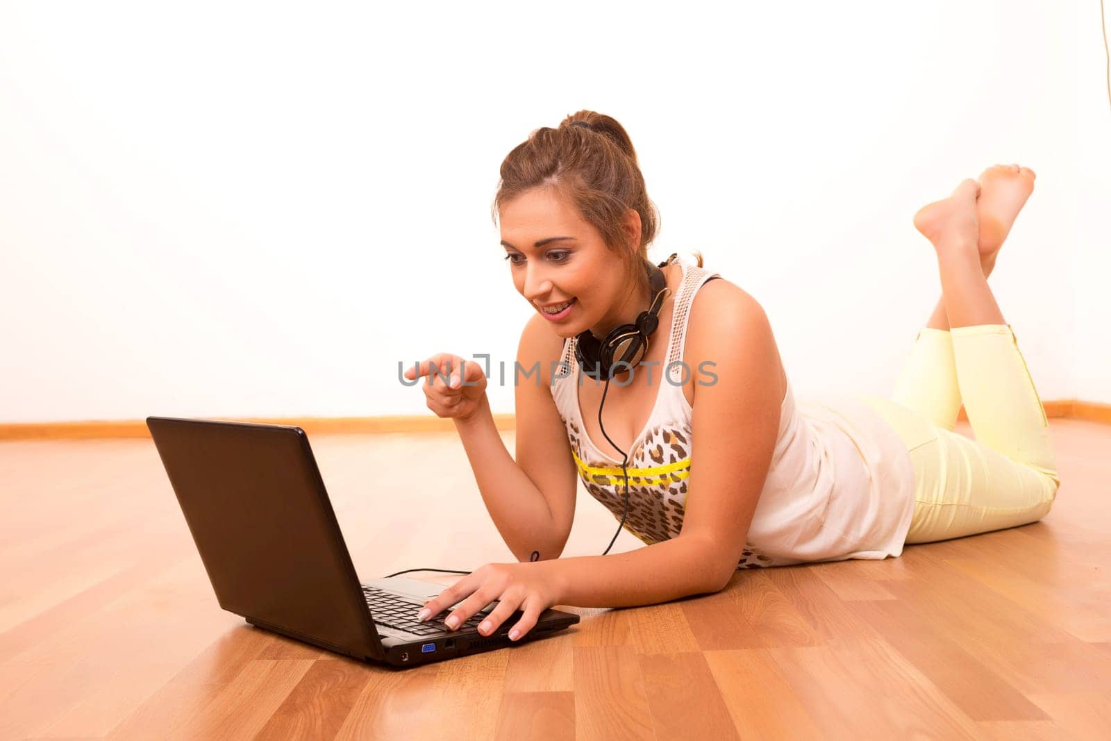Beautiful teenager relaxing at her living room with the company of a last generation computer