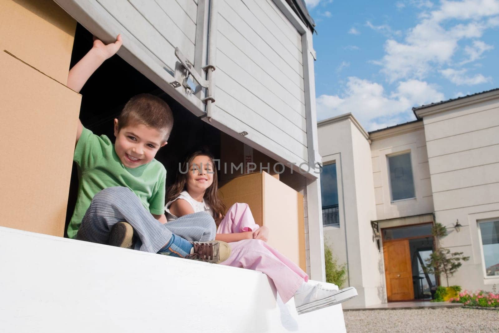 Portrait of a boy sitting with his sister in a pick_up truck and smiling