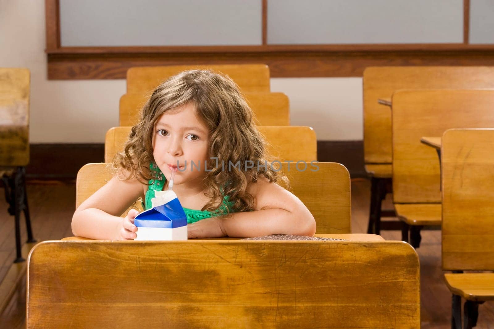 Schoolgirl drinking juice in a classroom