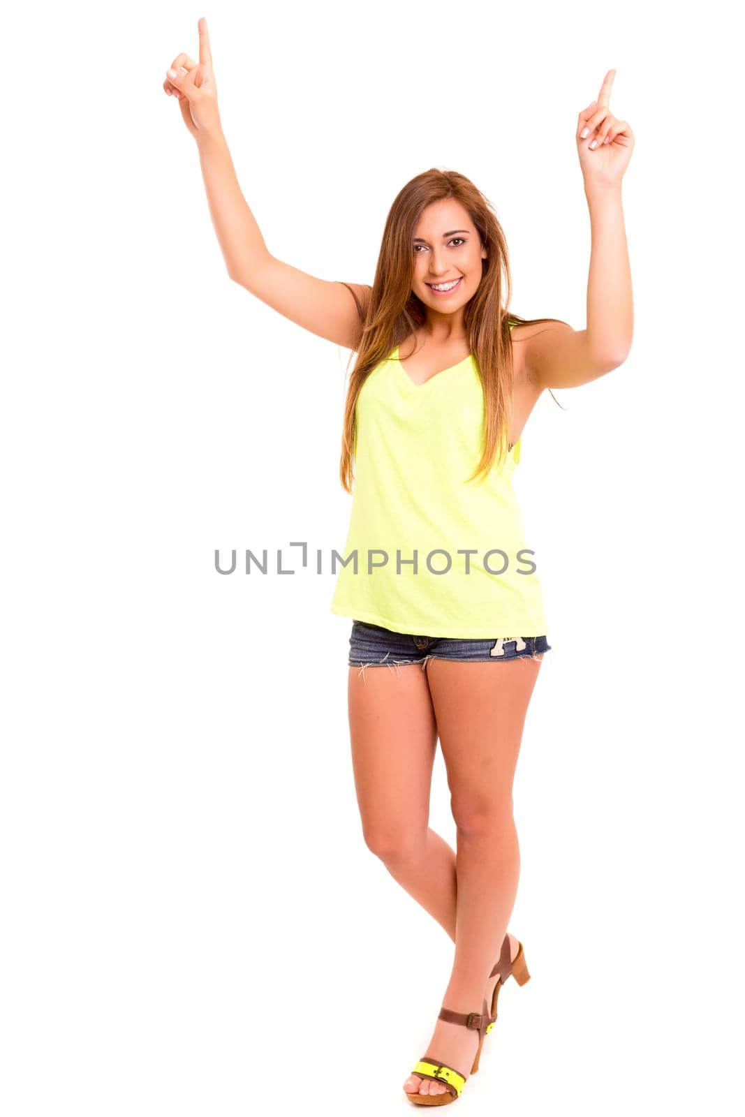 A beautiful teenager pointing to something, isolated over a white background