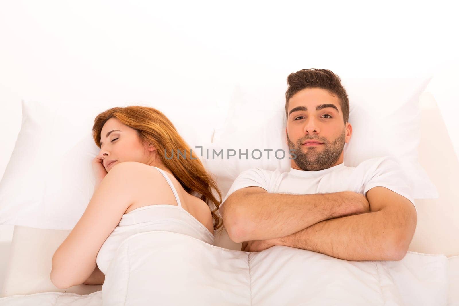 Young depressed couple in bed - daylife problems concept