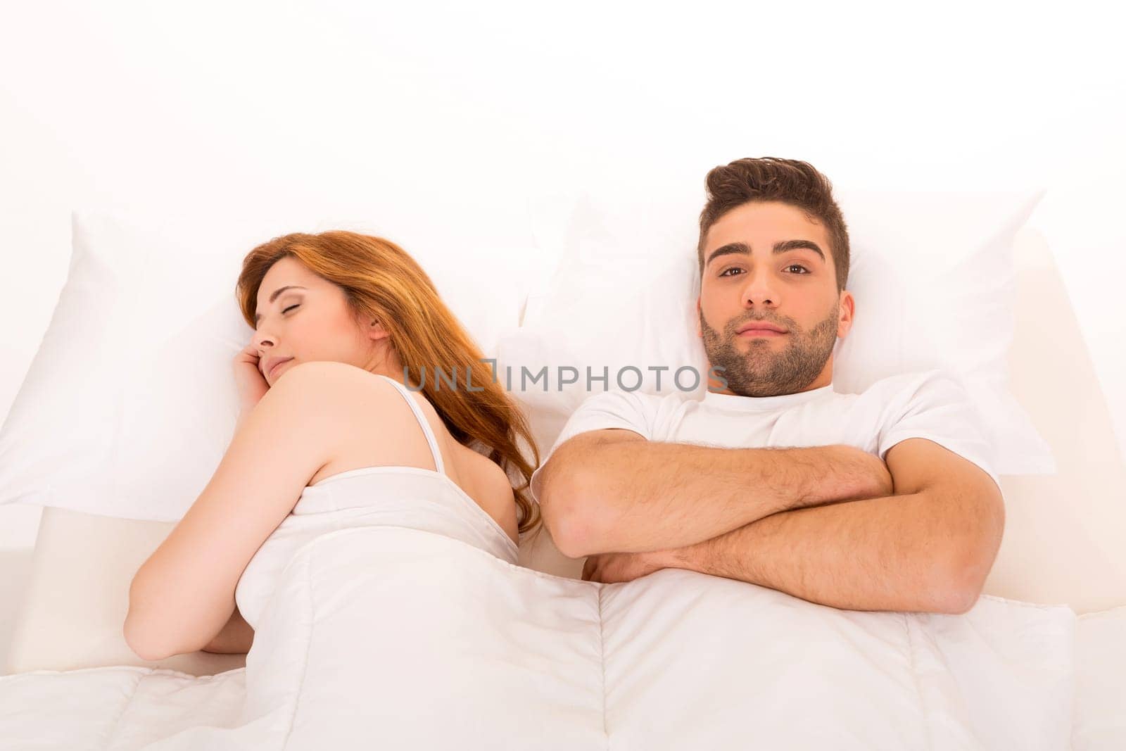 Young depressed couple in bed - daylife problems concept