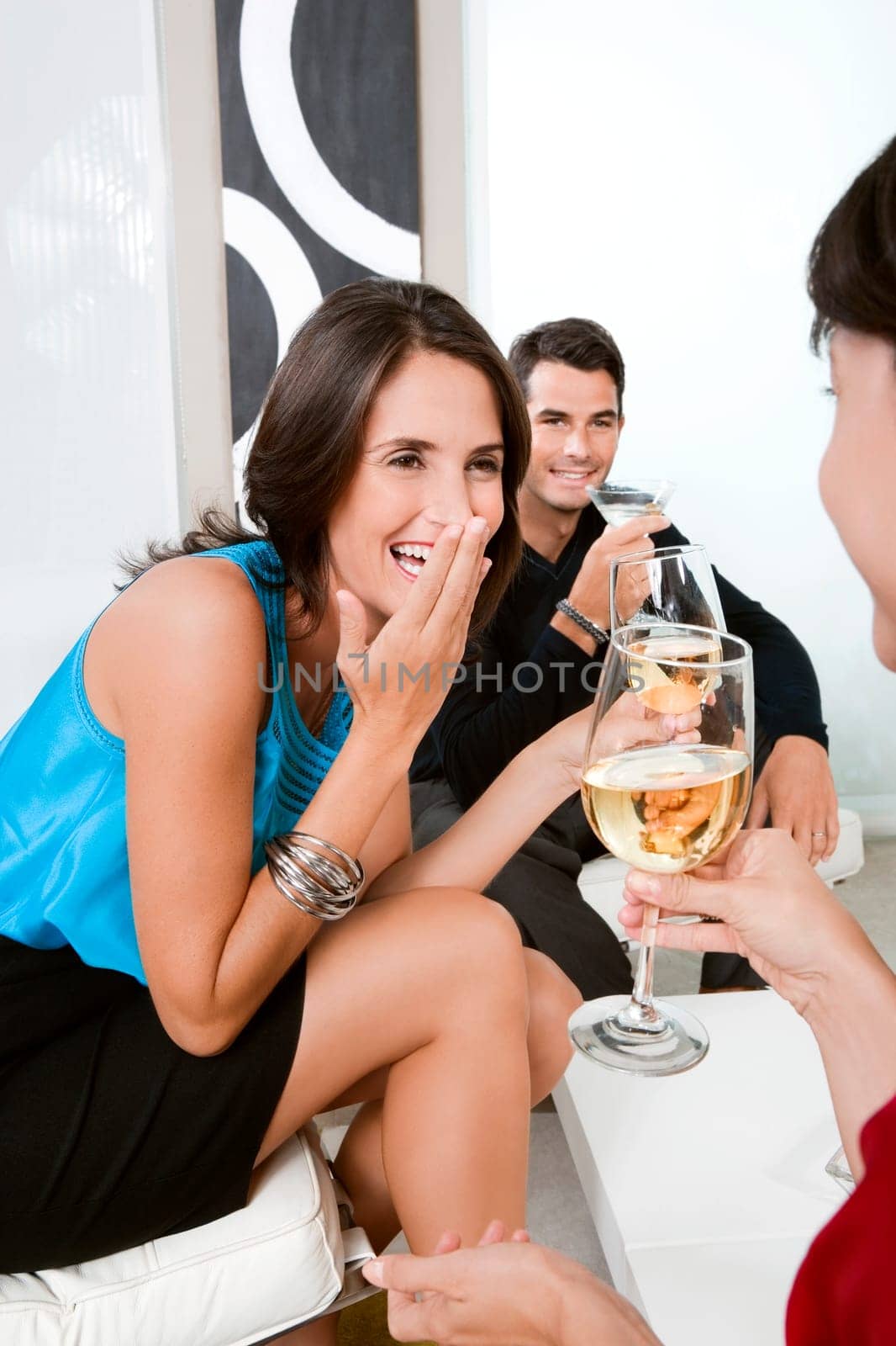 Three friends drinking wine and smiling together