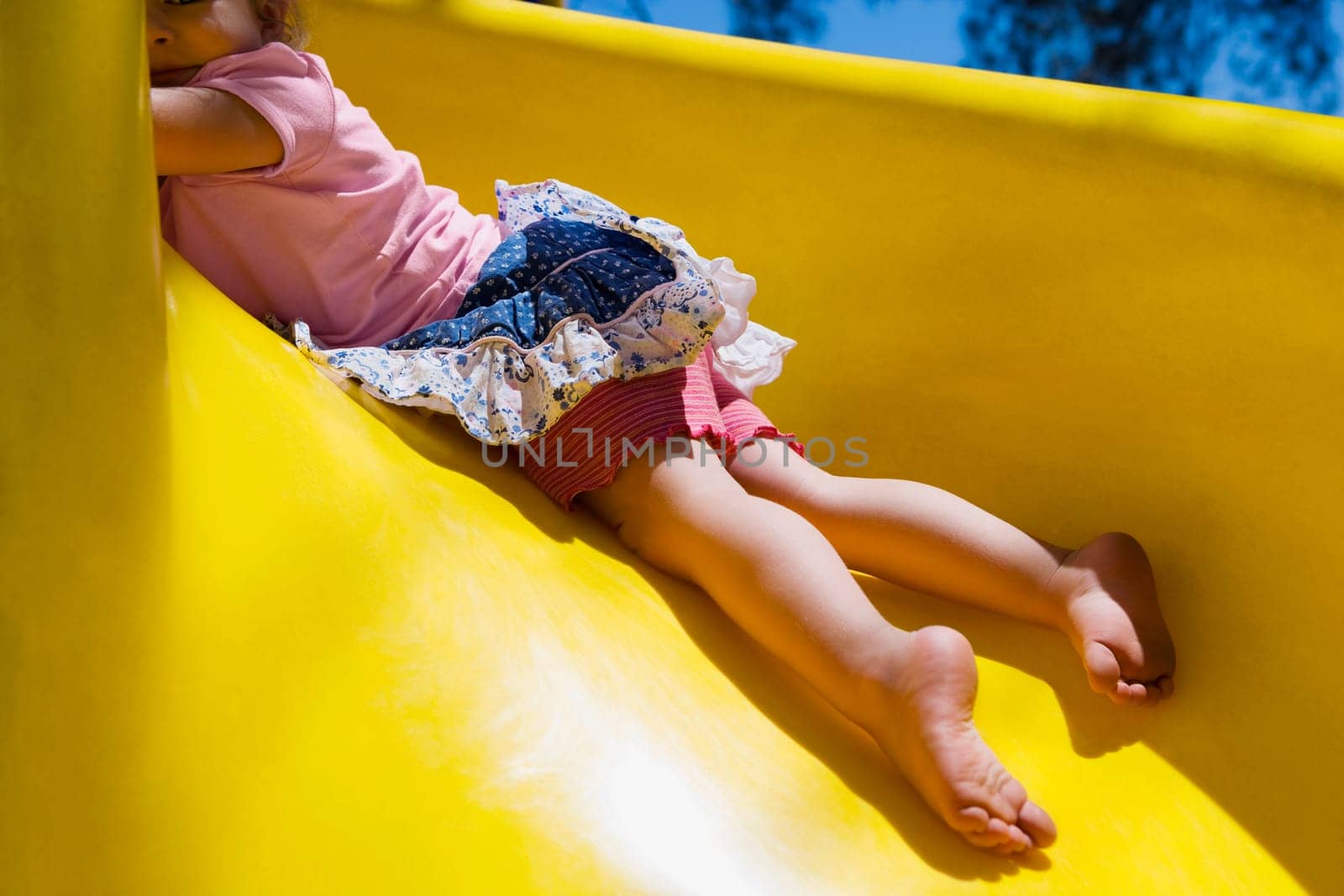 Baby girl playing on a slide, Santa Fe, New Mexico, USA