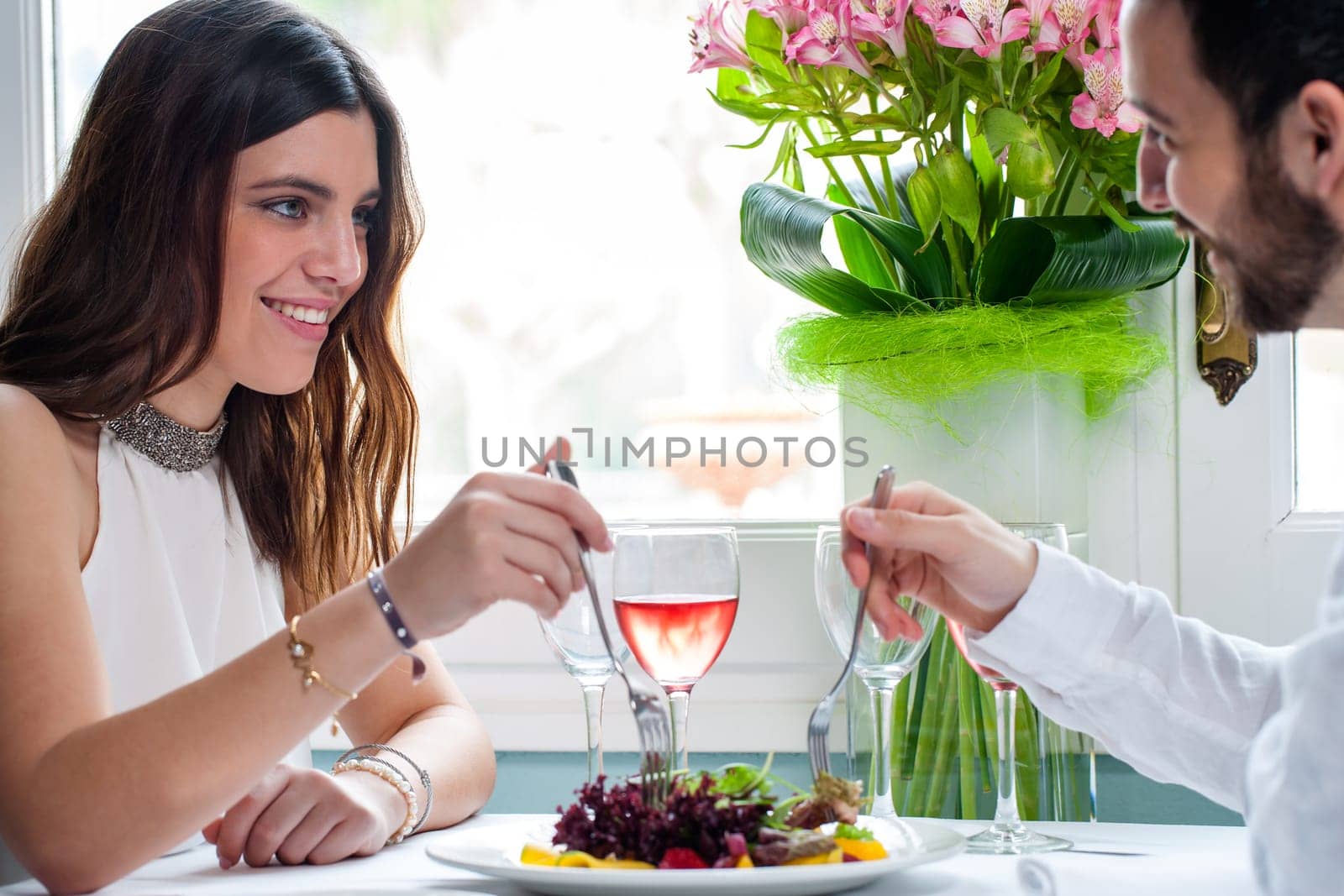 Close up portrait of attractive elegant brunette dining with boyfriend next to window in restaurant.