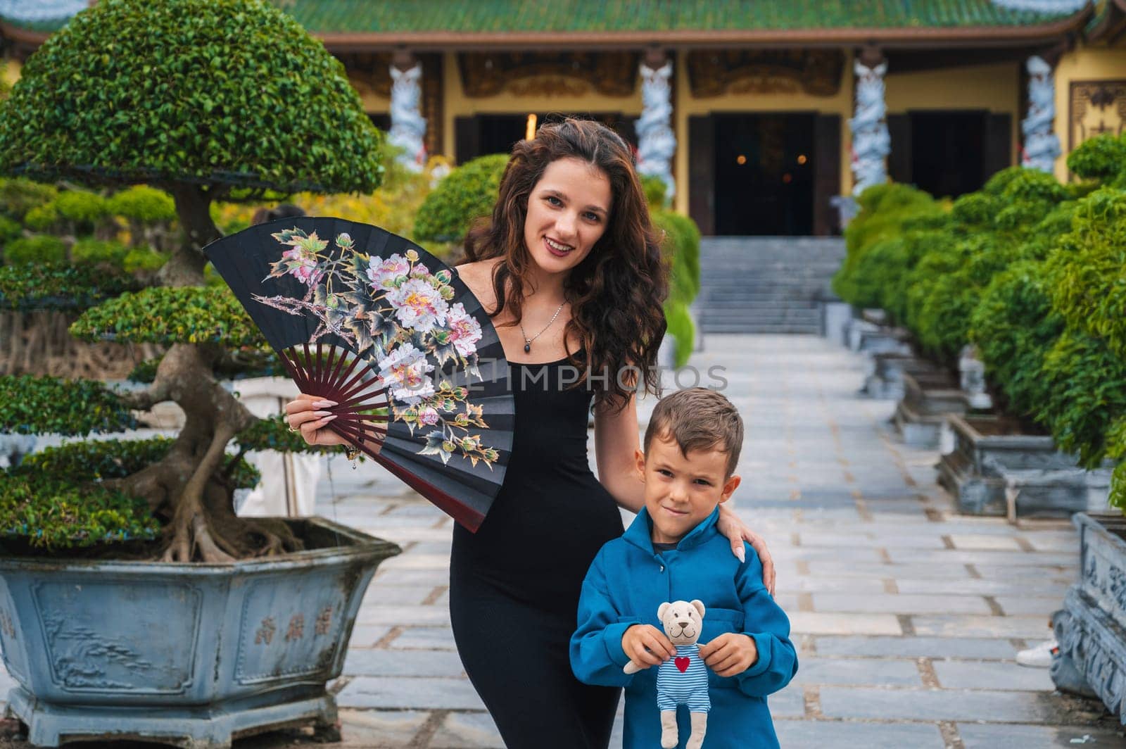 family of tourists mom and son at Buddhist temple at Linh Ung Pagoda in Da Nang in Vietnam. Concept of travel and tourism in Asia
