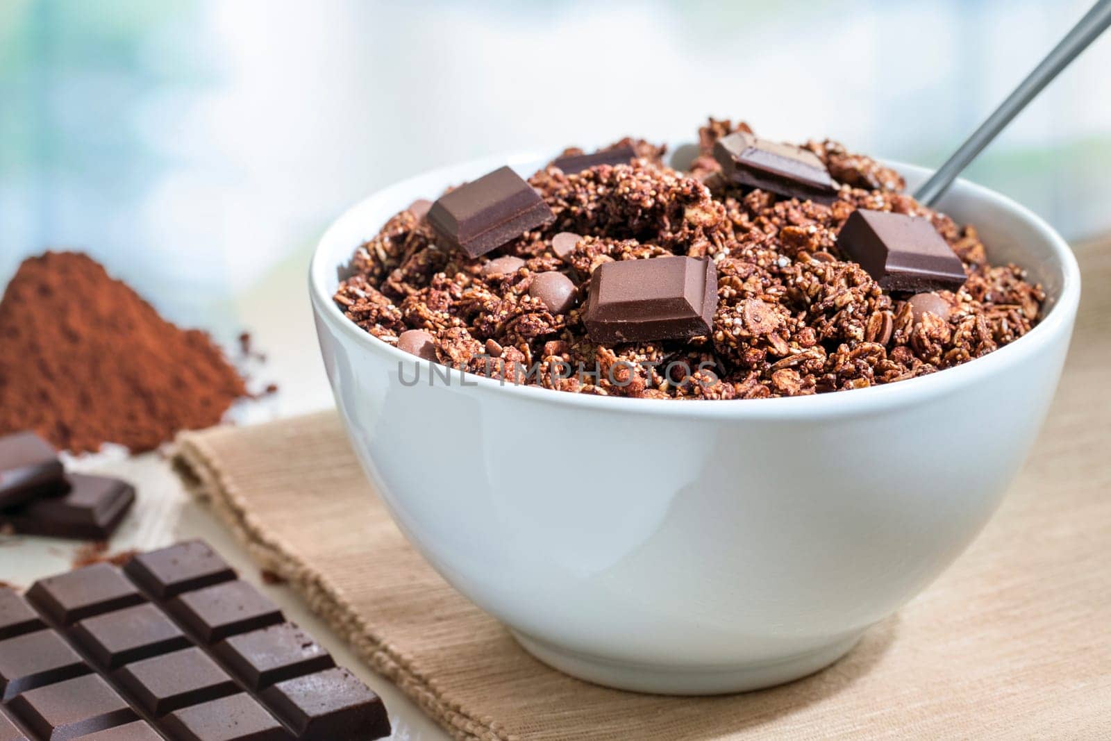 Extreme close up of Healthy muesli breakfast.Chocolate muesli with slab and cacao powder in background.
