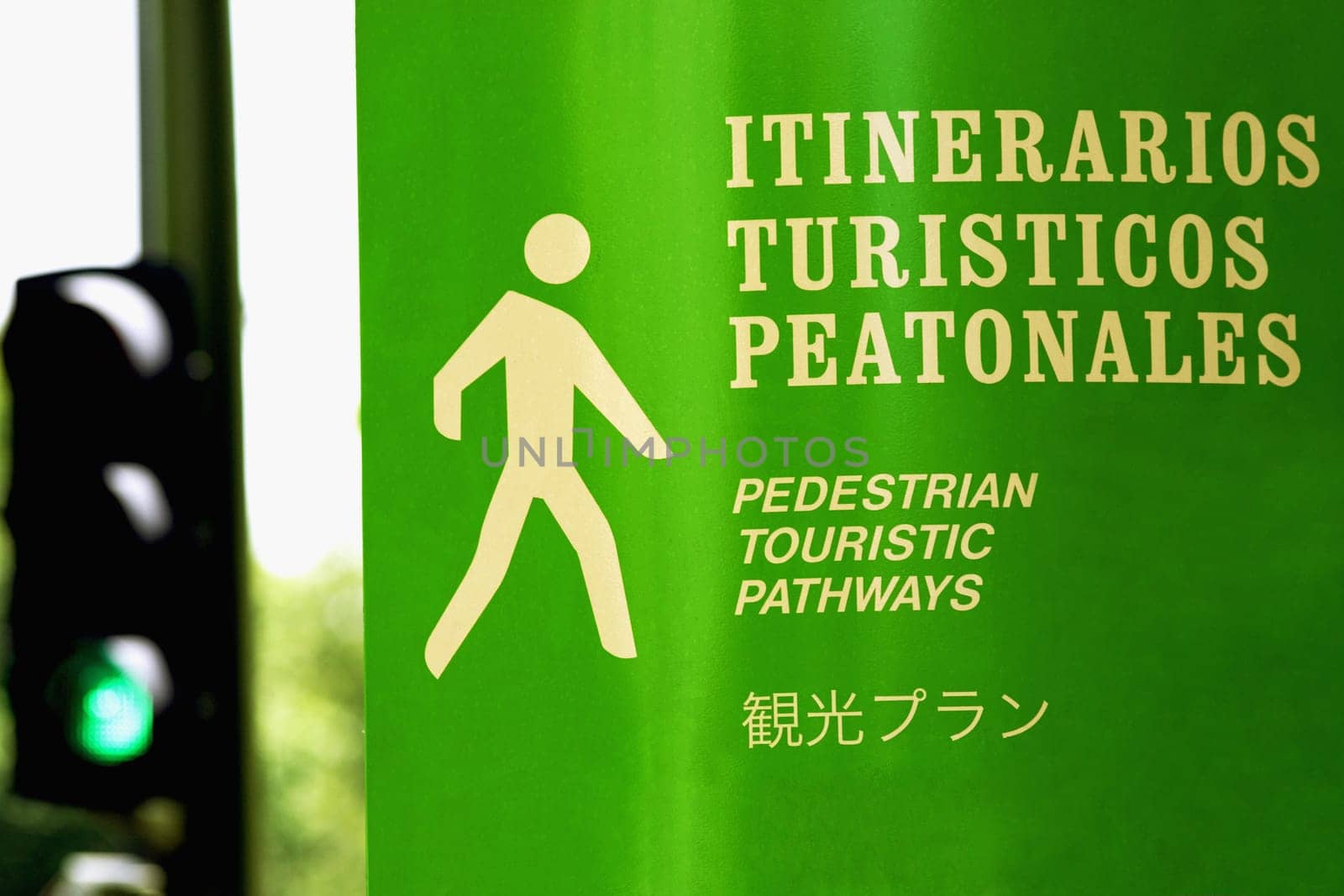 Close_up of a pedestrian walkway sign with a traffic light in the background, Madrid, Spain