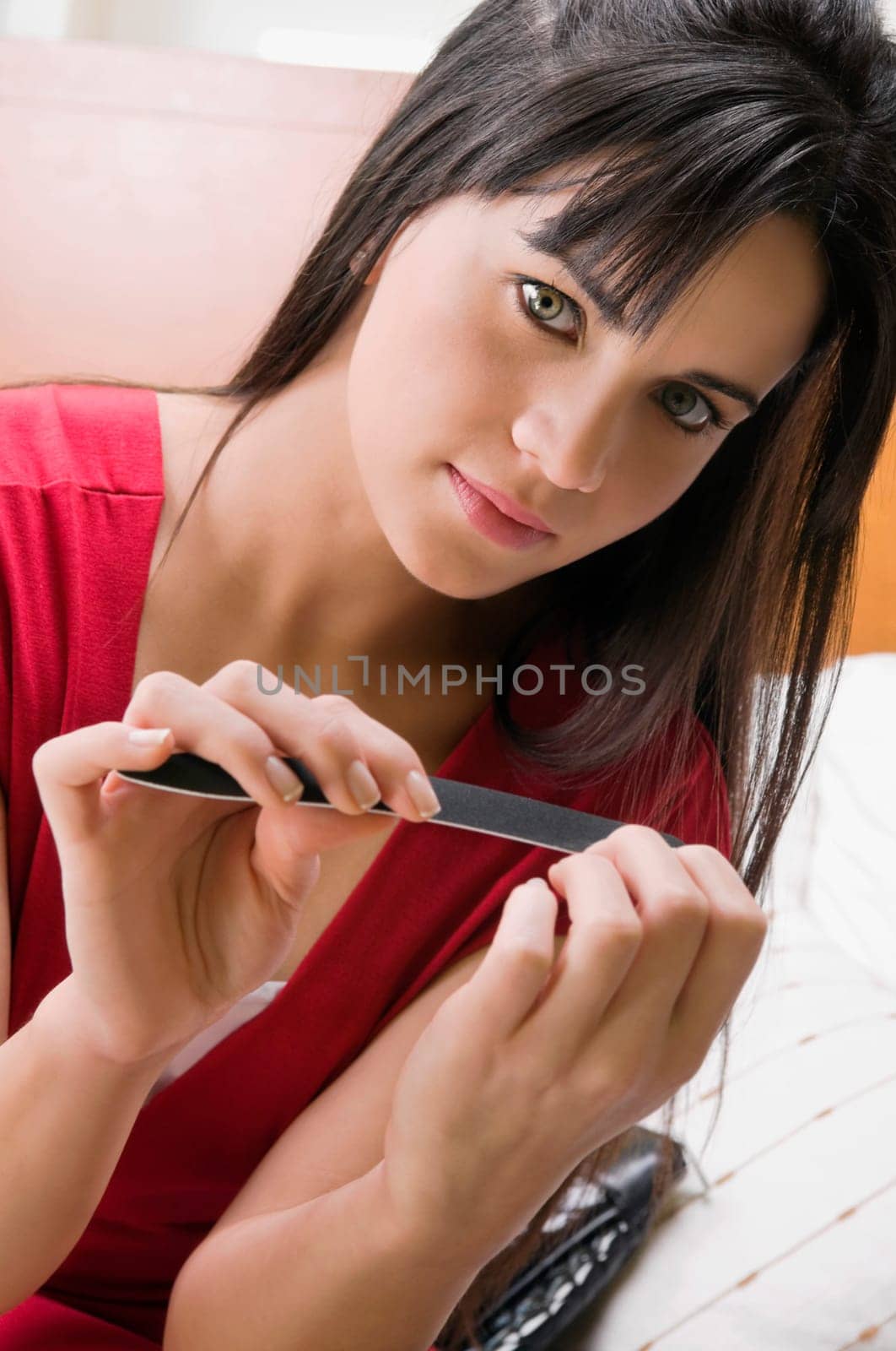 Portrait of a young woman filing her nails