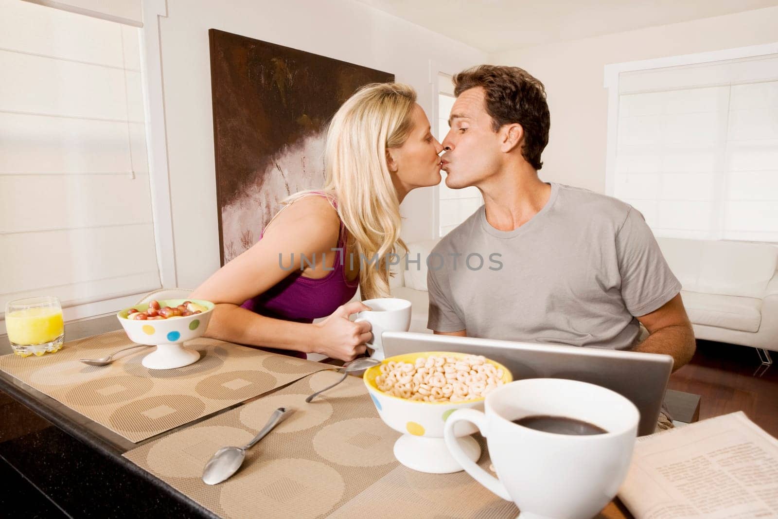 Couple kissing each other at a breakfast