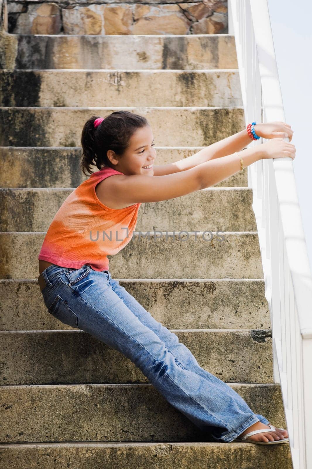 Side profile of a girl holding a railing and standing on the staircase