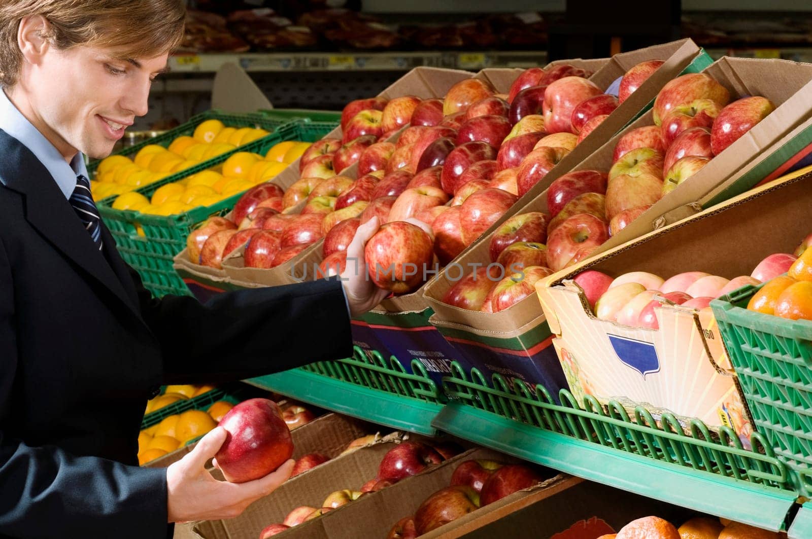 Businessman buying apples in a supermarket