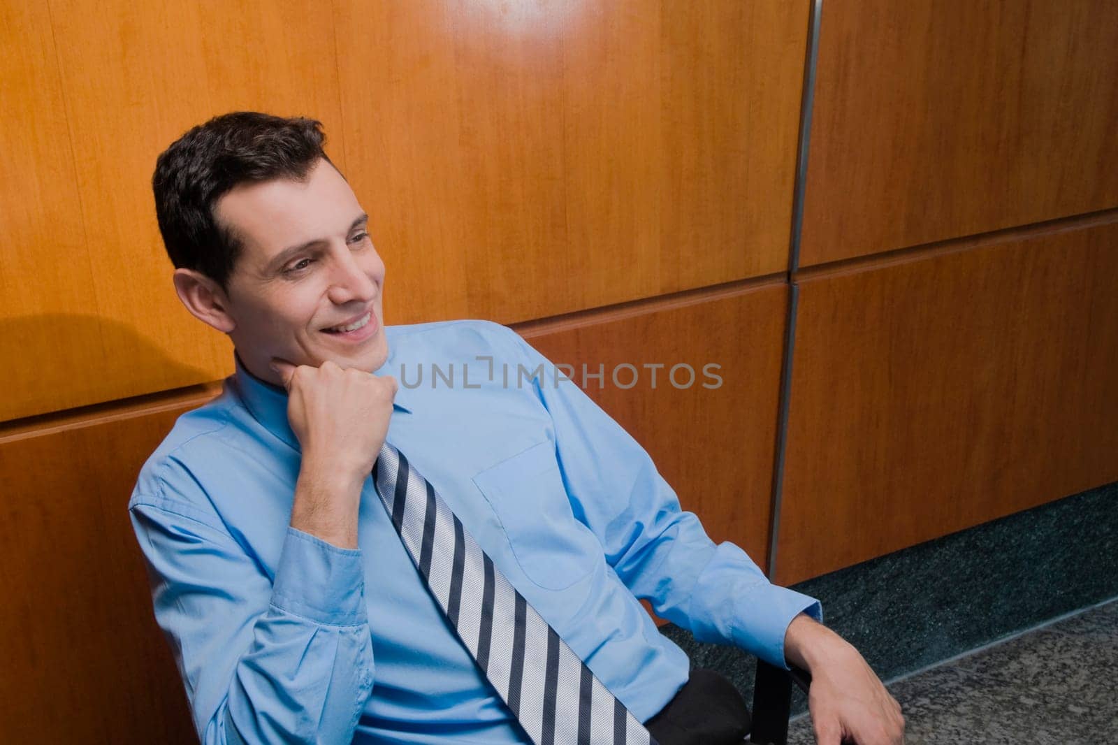 Businessman sitting in an office chair and day dreaming