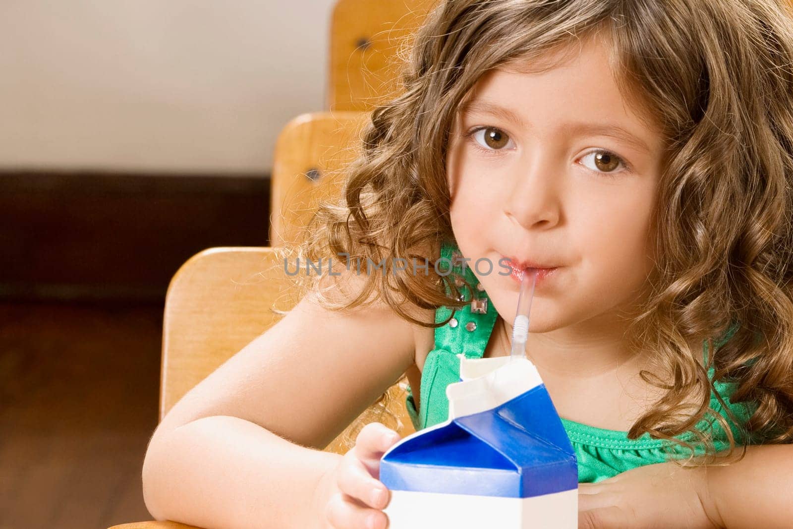 Schoolgirl drinking juice in a classroom