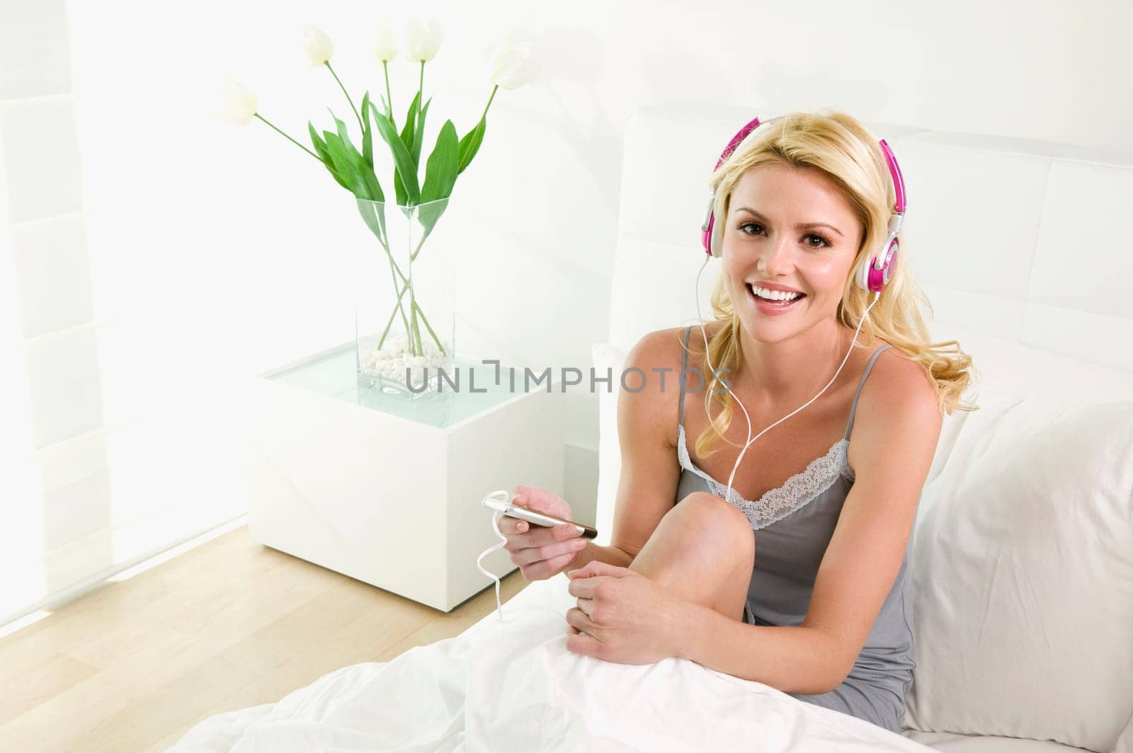Young woman listening to an MP3 player and smiling