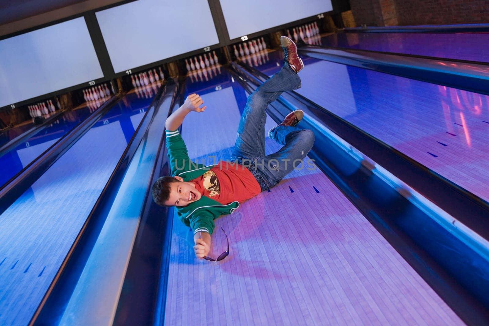 High angle view of a young man sliding in a bowling alley