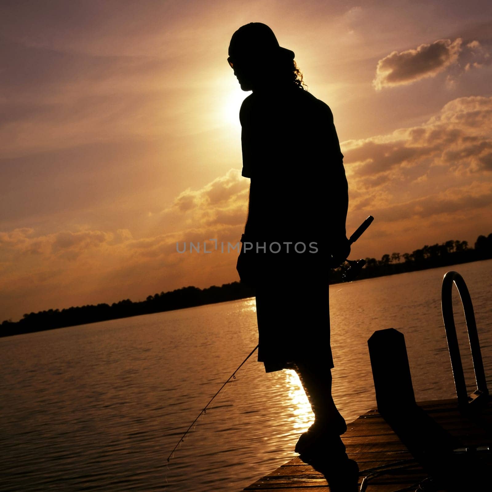 Silhouette of a man holding a fishing rod