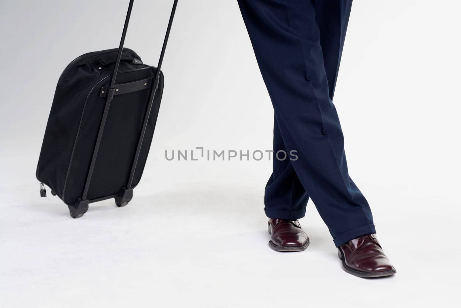 Low section view of a man standing with a suitcase