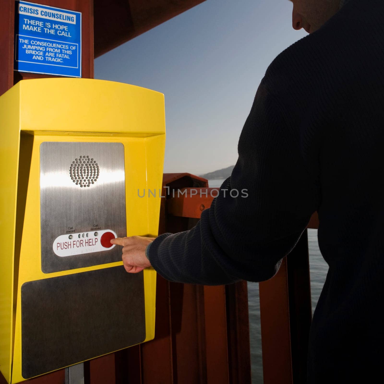 Tourist pressing emergency call button on a bridge, Golden Gate Bridge, San Francisco Bay, San Francisco, California, USA
