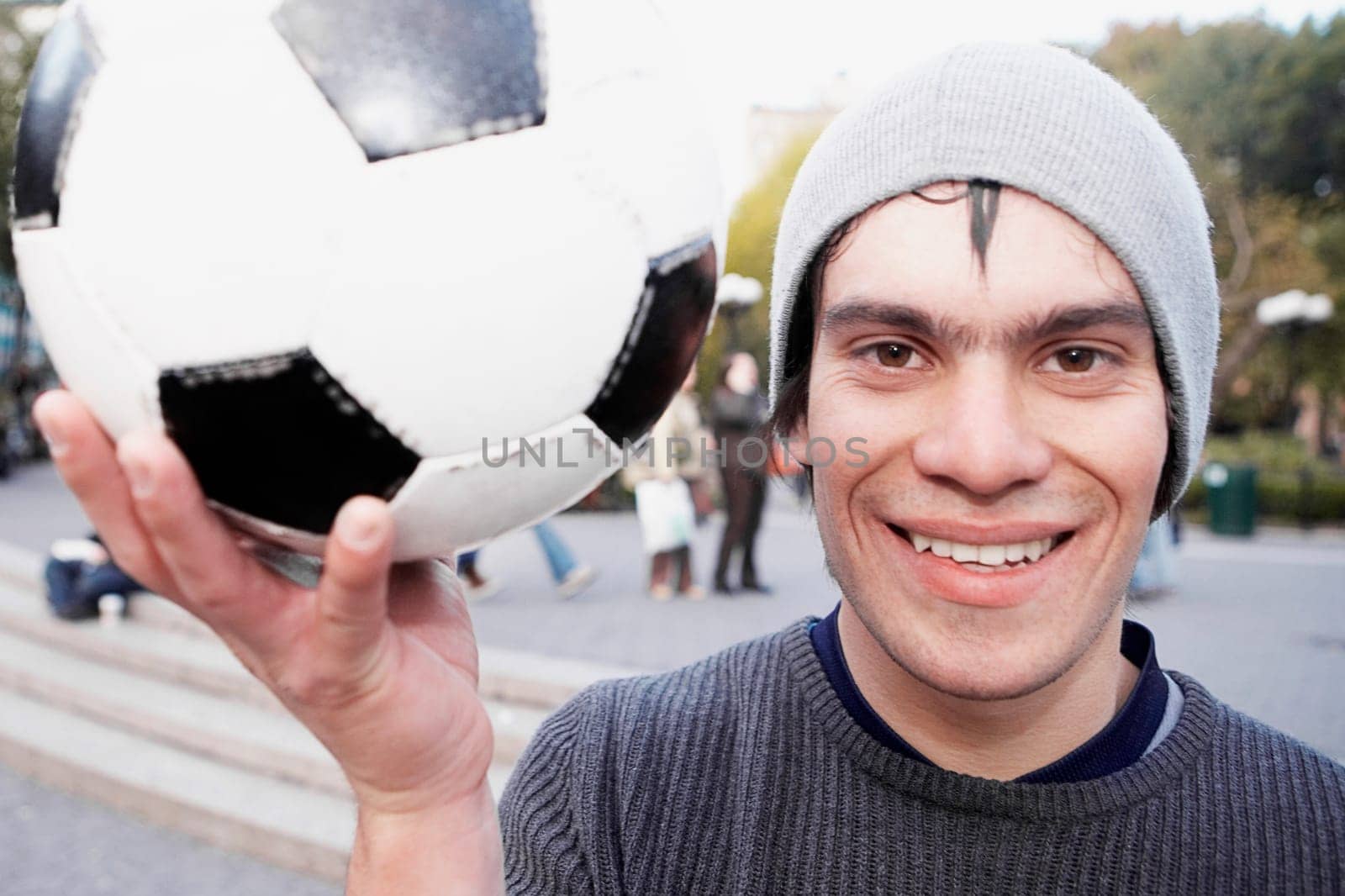 Portrait of a young man holding a soccer ball and smiling
