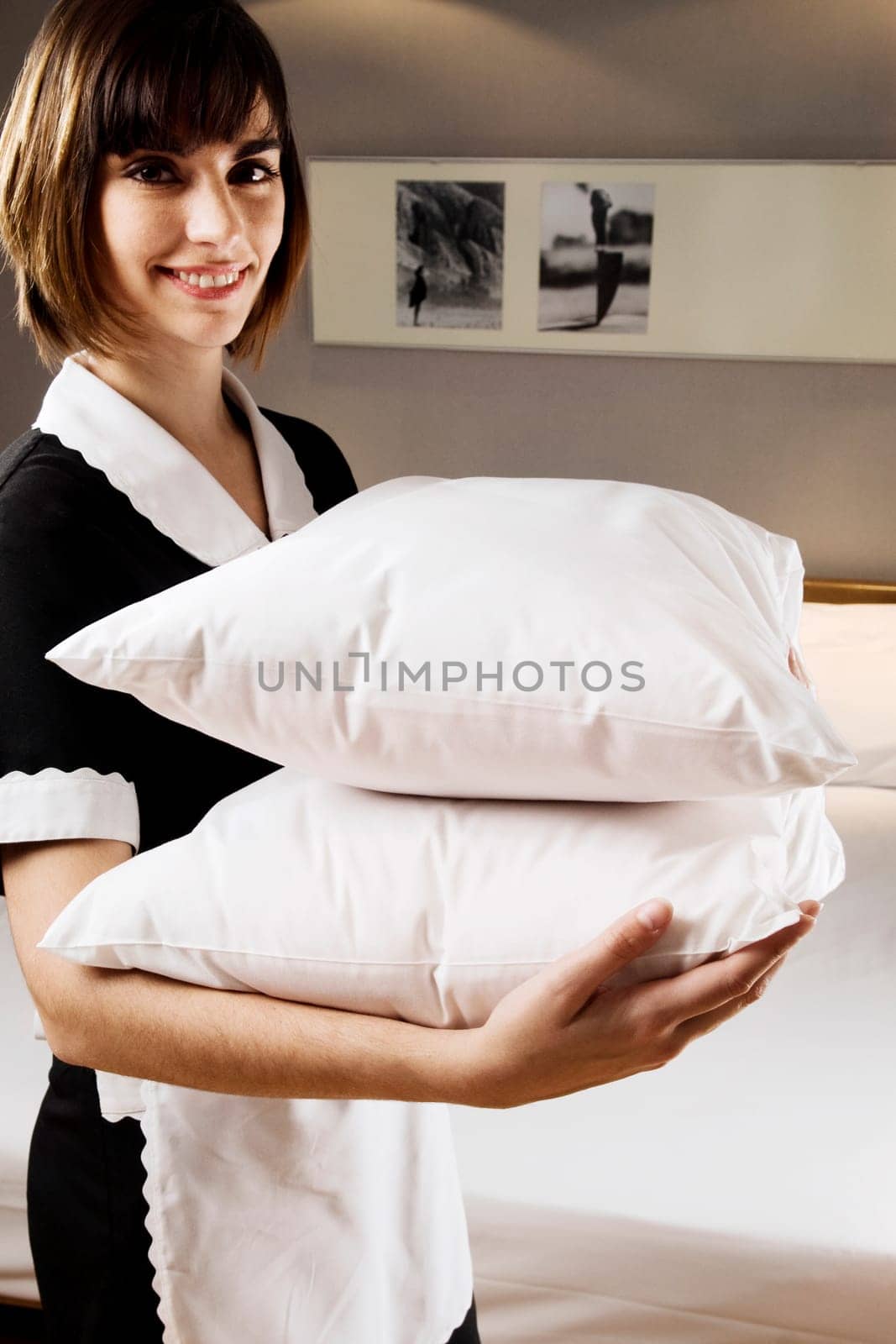 Portrait of a waitress holding pillows