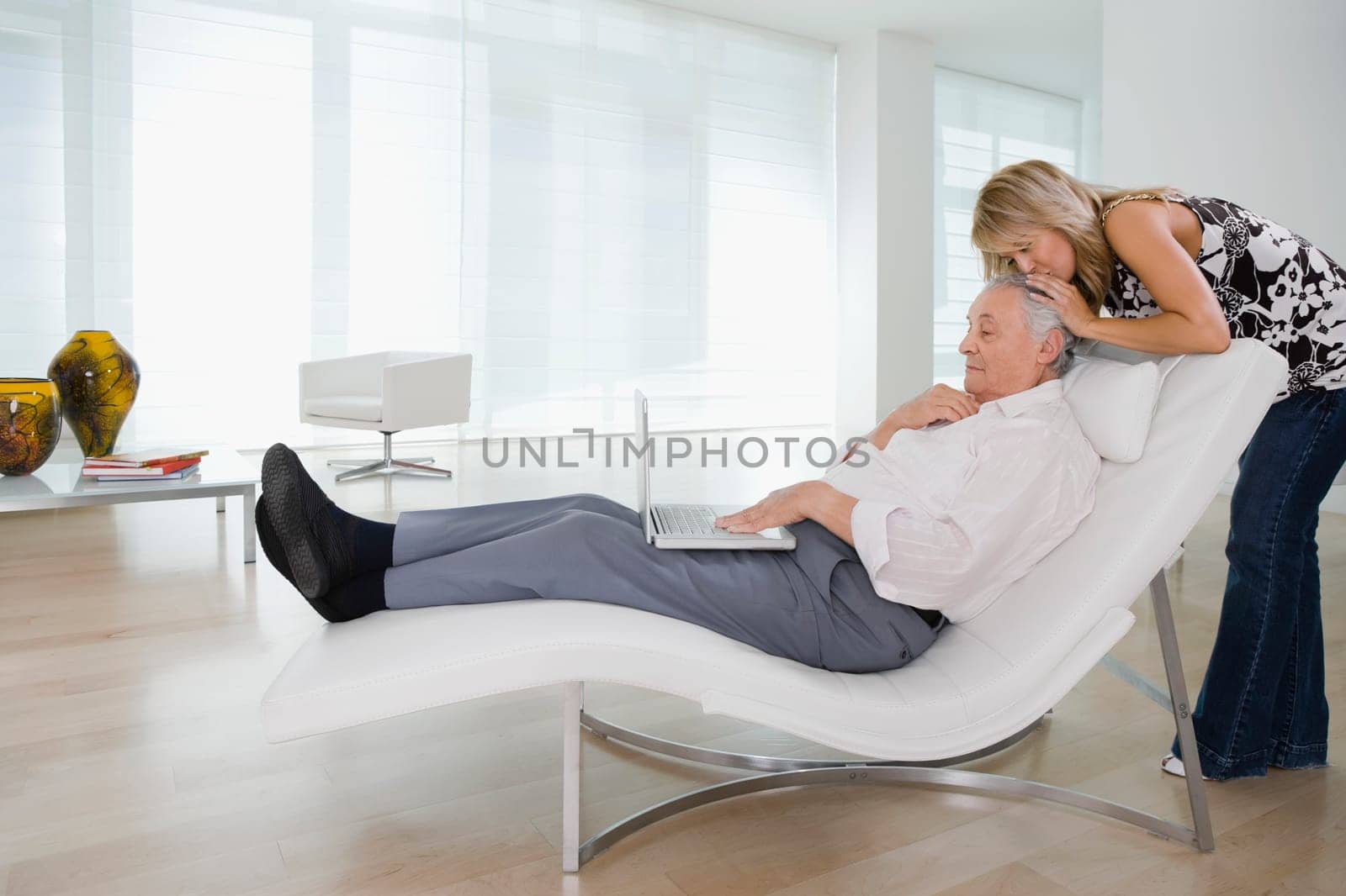 Young woman kissing the head of her grandfather