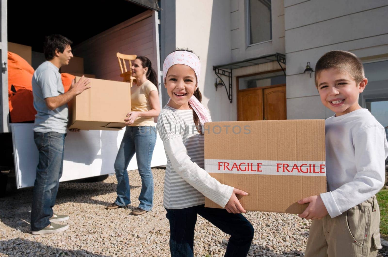 Couple with their children unloading boxes from a pick_up truck