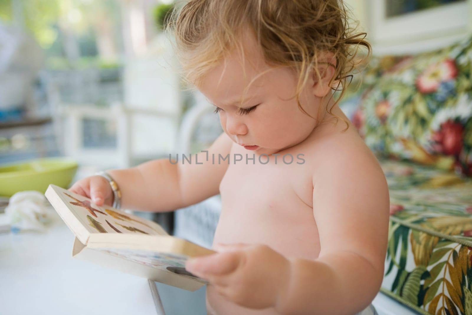 Close_up of a baby girl holding a book