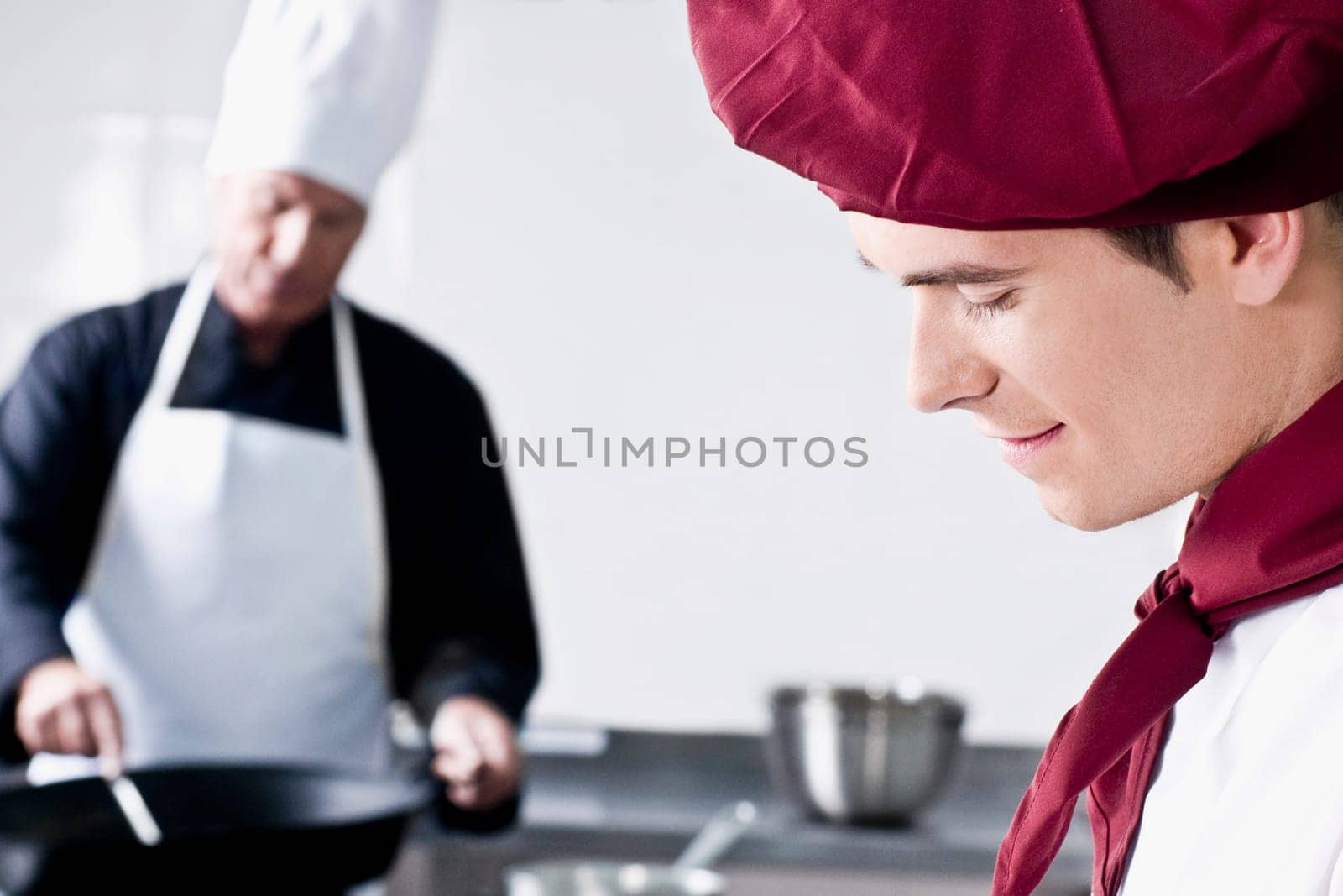 Two chefs cooking food in the kitchen