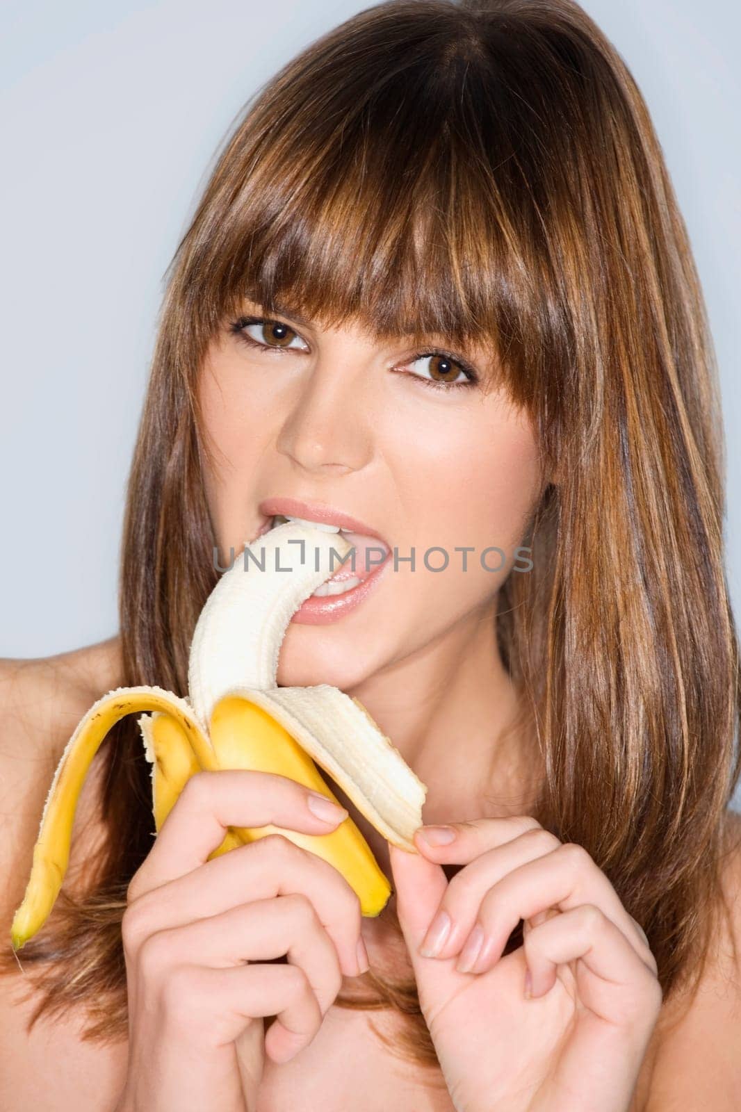 Portrait of a young woman eating a banana