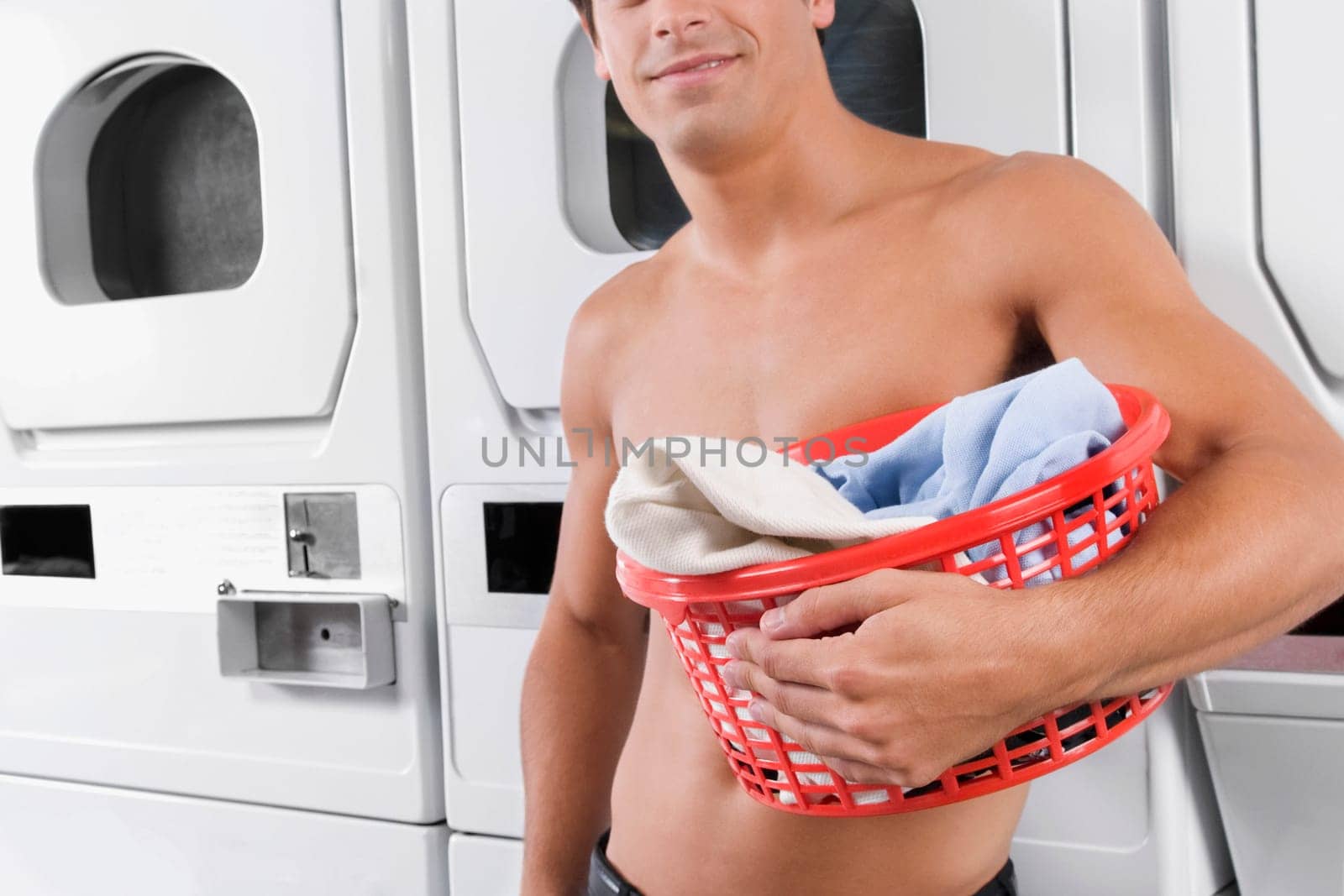 Man carrying a laundry basket in a laundromat