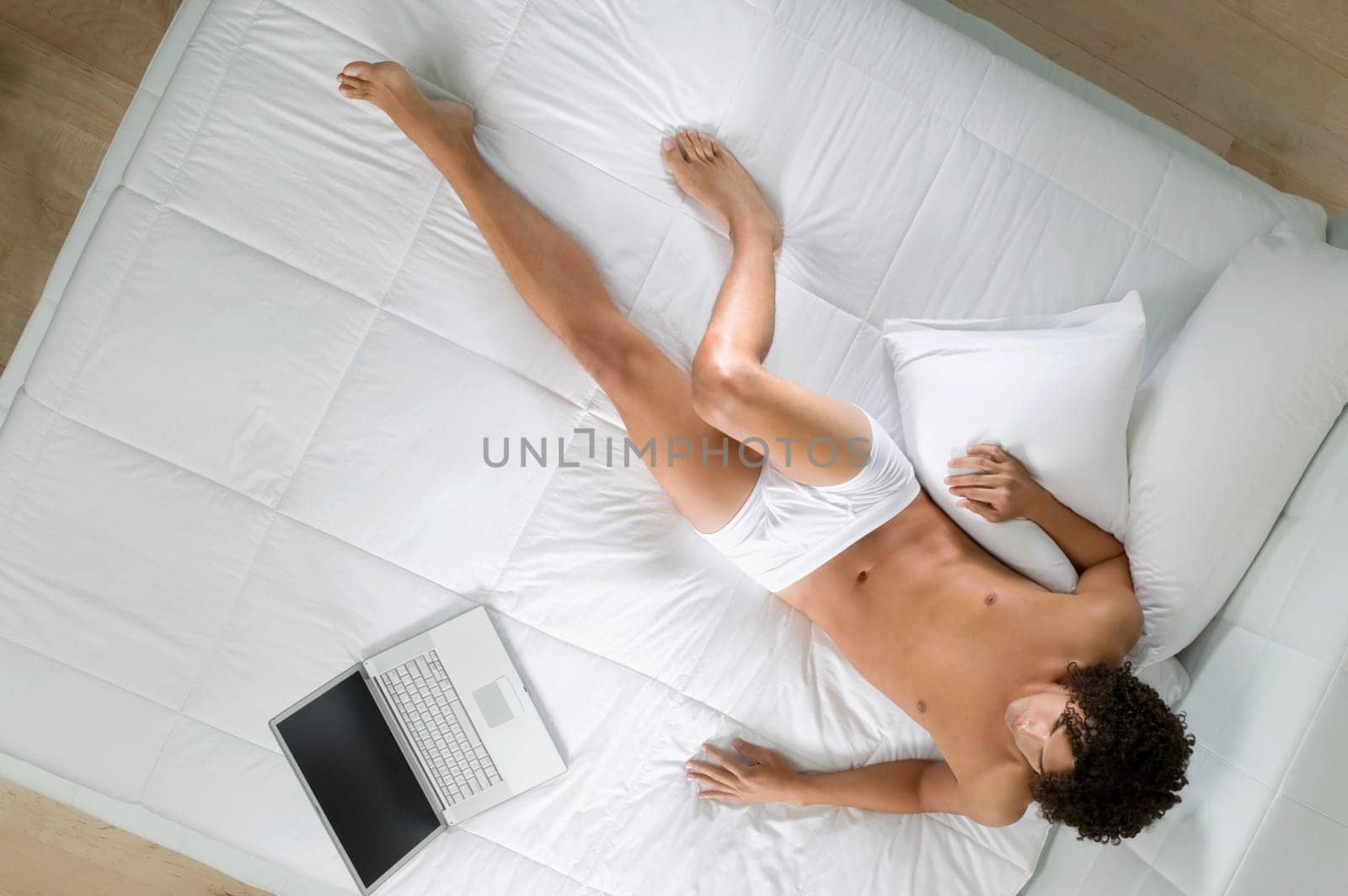 High angle view of a young man lying on the bed