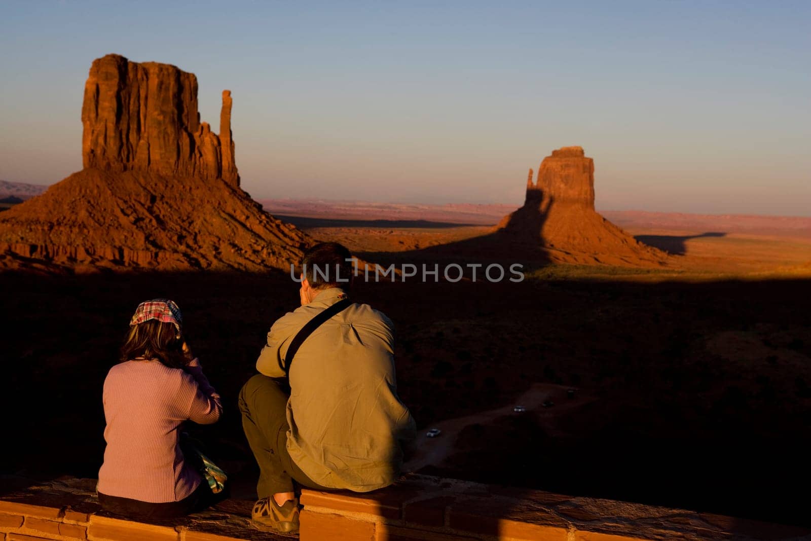 Tourists looking at rock formations in a valley, Monument Valley Tribal Park, Arizona_Utah, USA