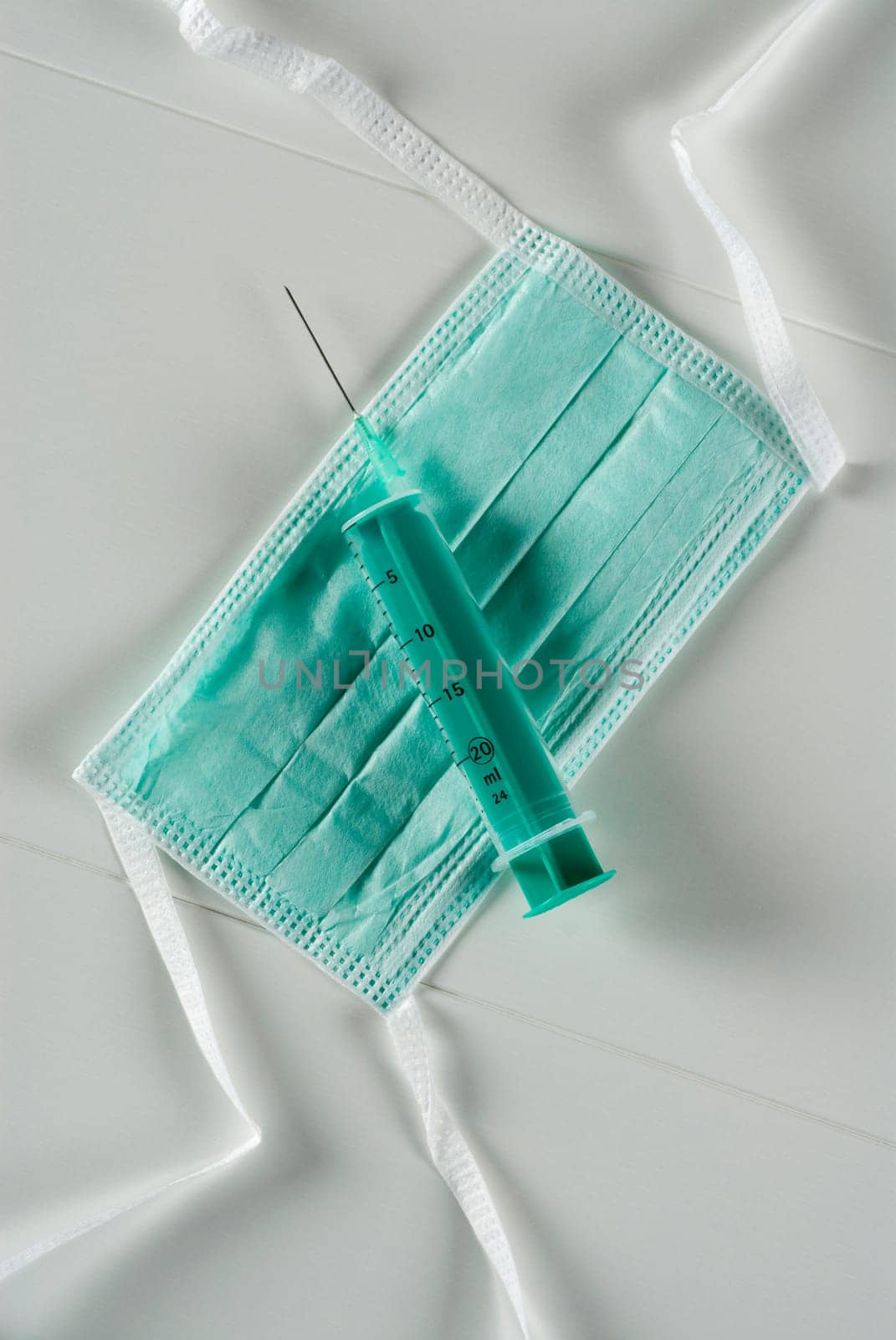 High angle view of a syringe on a surgical mask