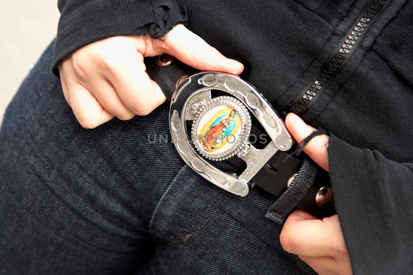 Close_up of a young woman holding her belt