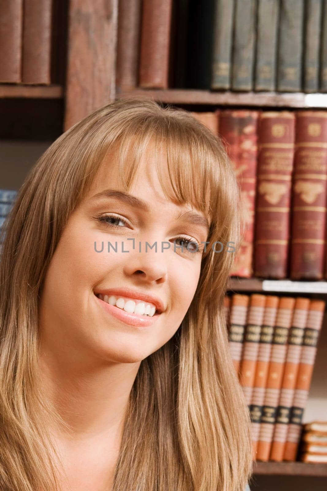 Portrait of a woman smiling in a library