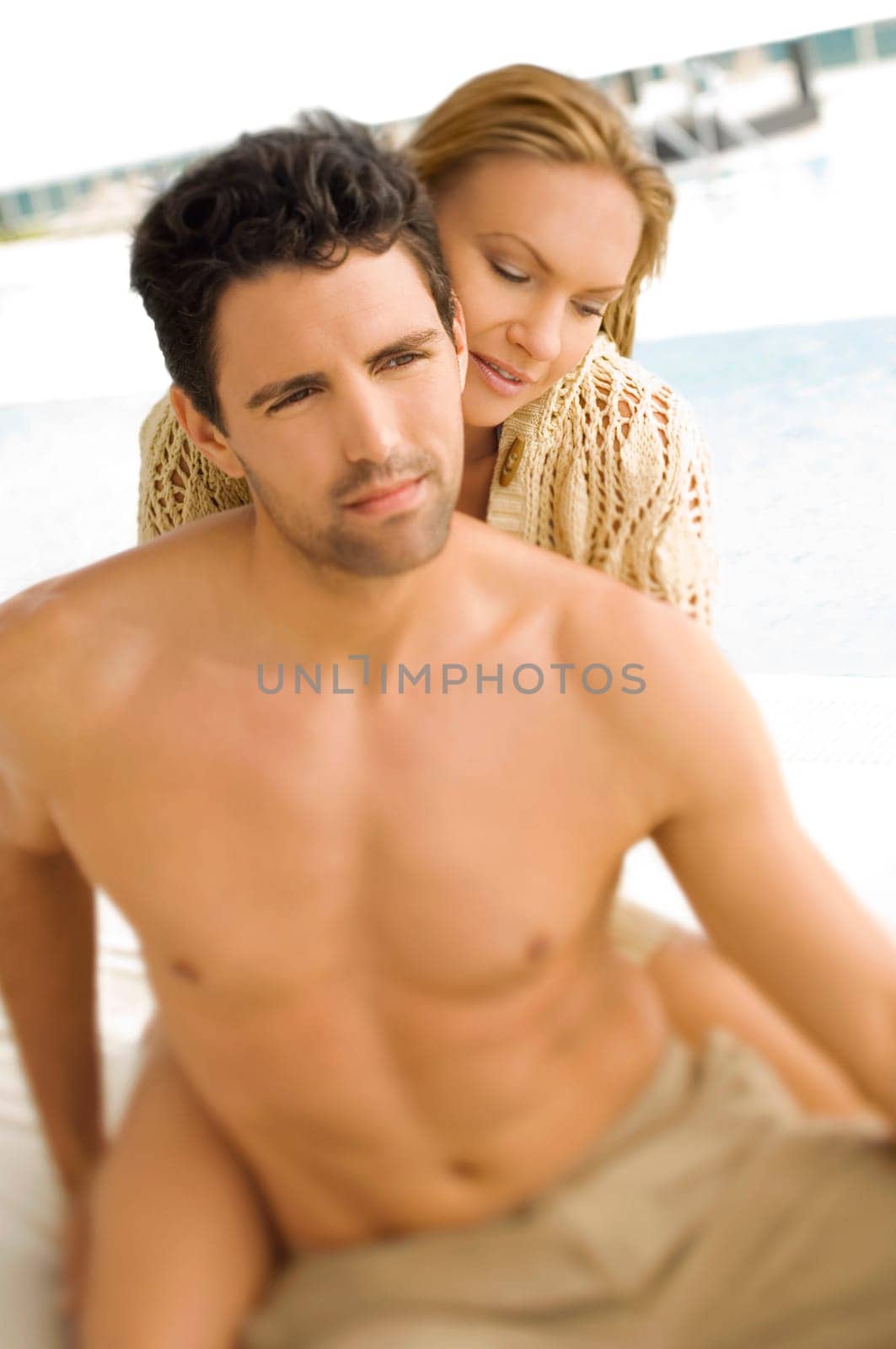 Close_up of a mid adult couple romancing at poolside