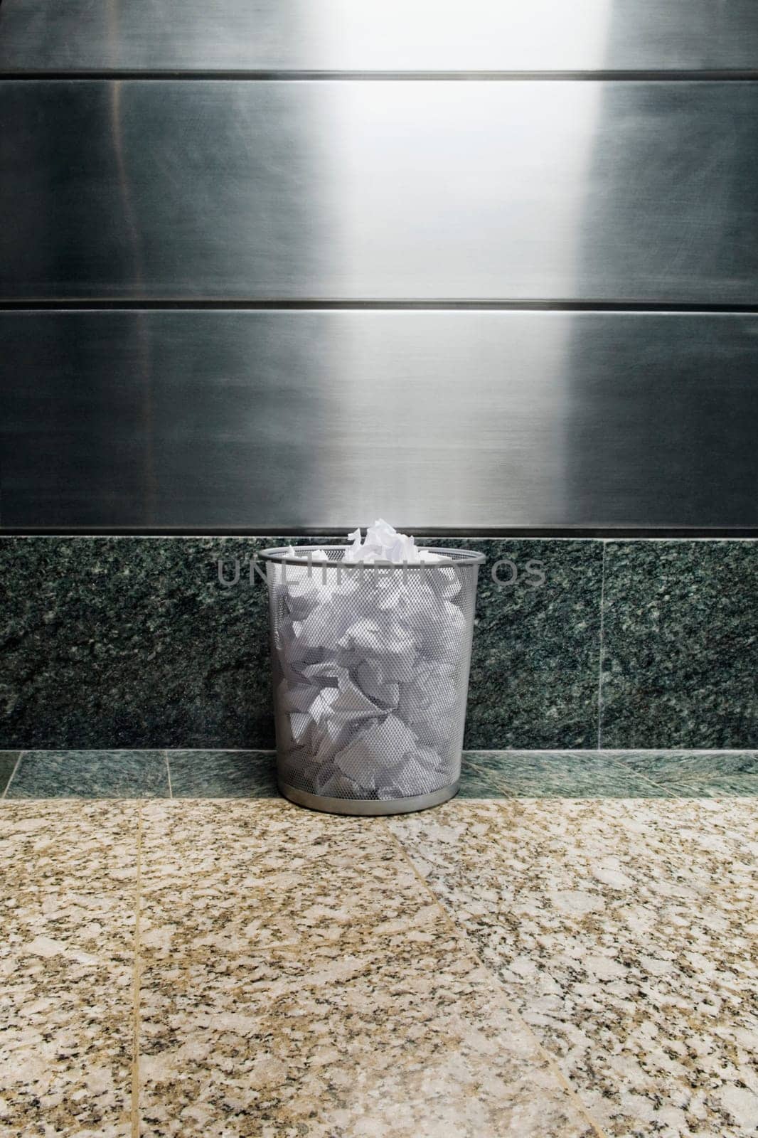 Garbage bin in front of a wall
