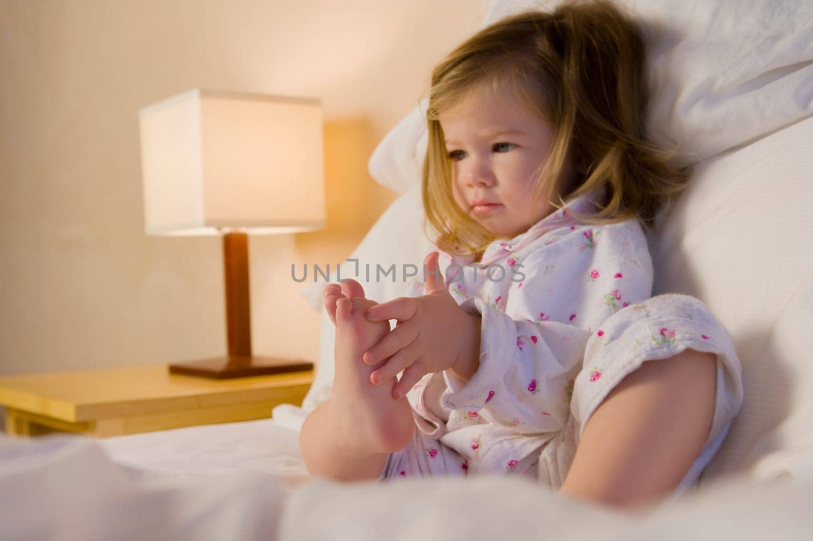 Baby girl sitting on the bed