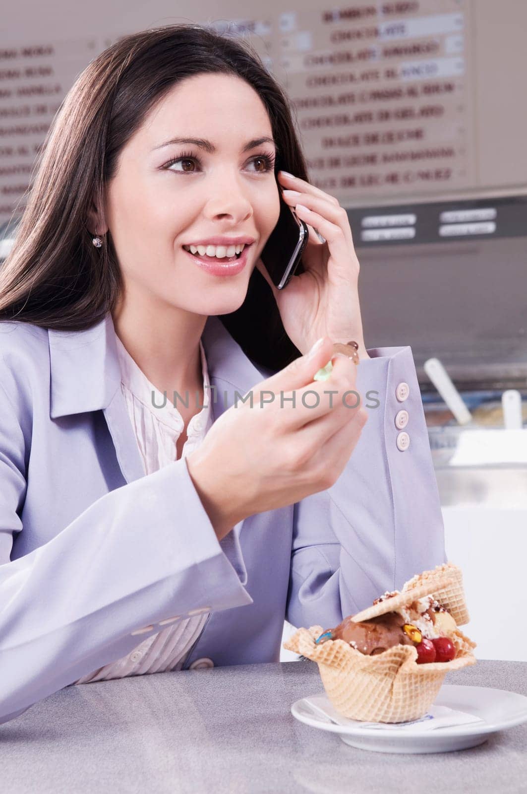 Woman eating ice cream and talking on a mobile phone